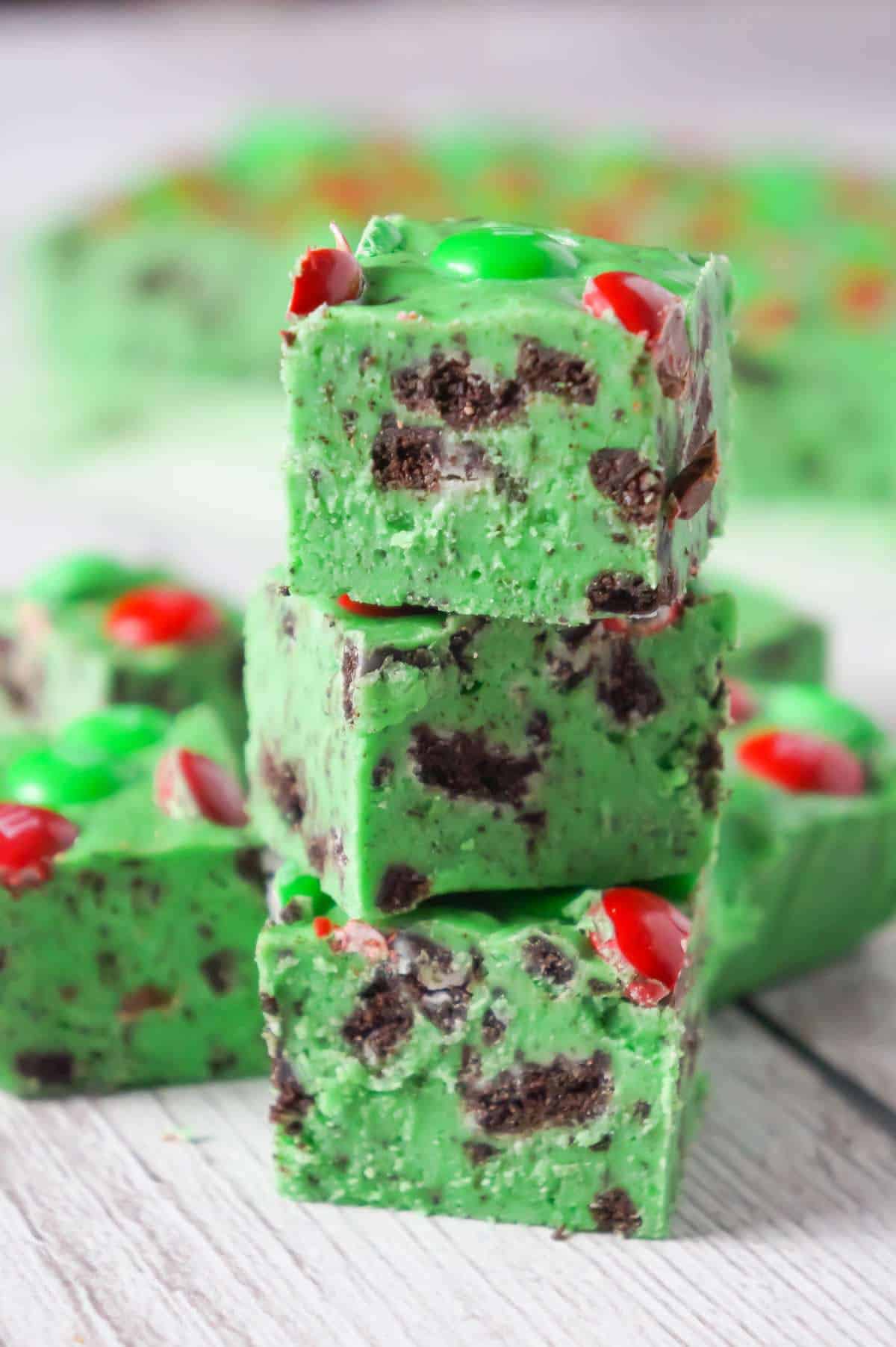 Cookies and Cream Christmas Fudge is an easy microwave fudge recipe made with vanilla frosting, white chocolate chips, green food colouring, crumbled Oreos and topped with red and green M&M's.