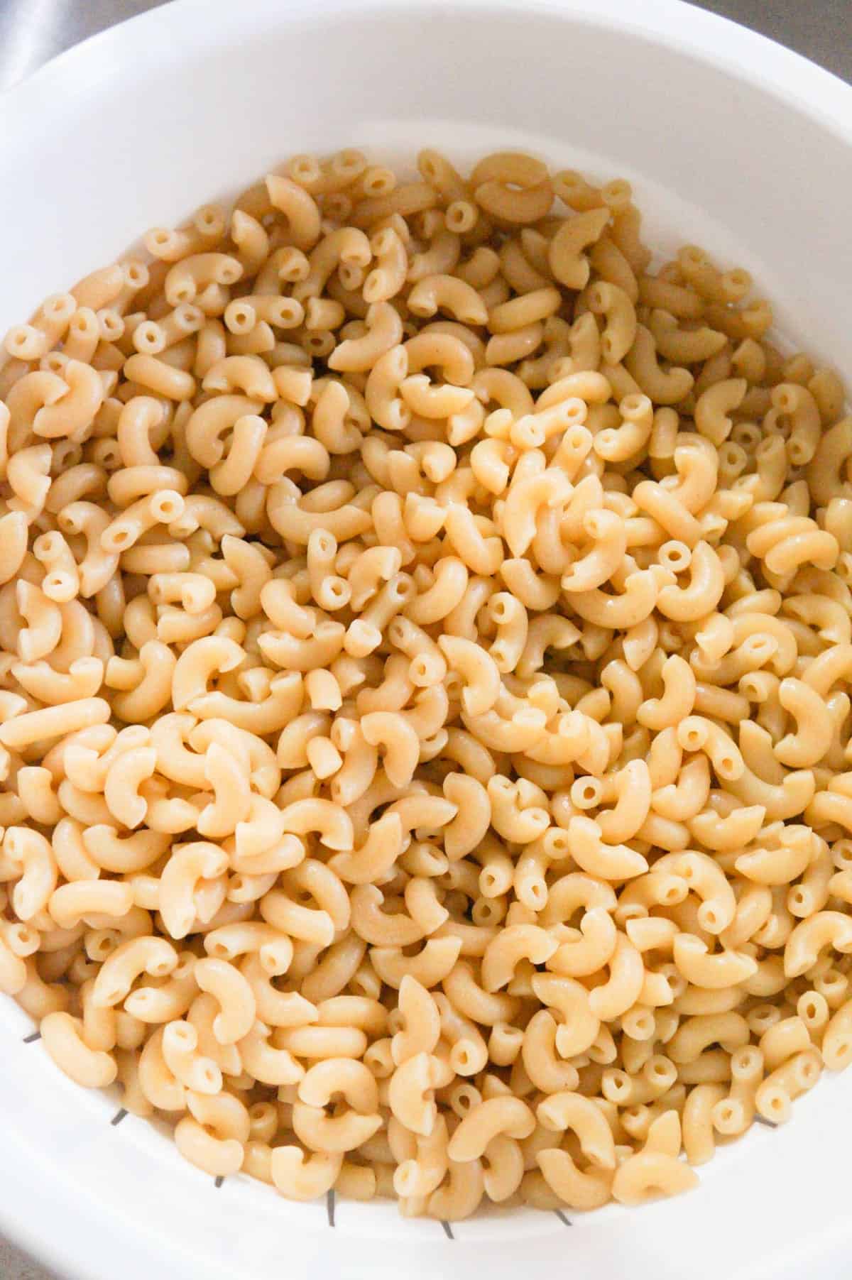 cooked macaroni noodles in a strainer 