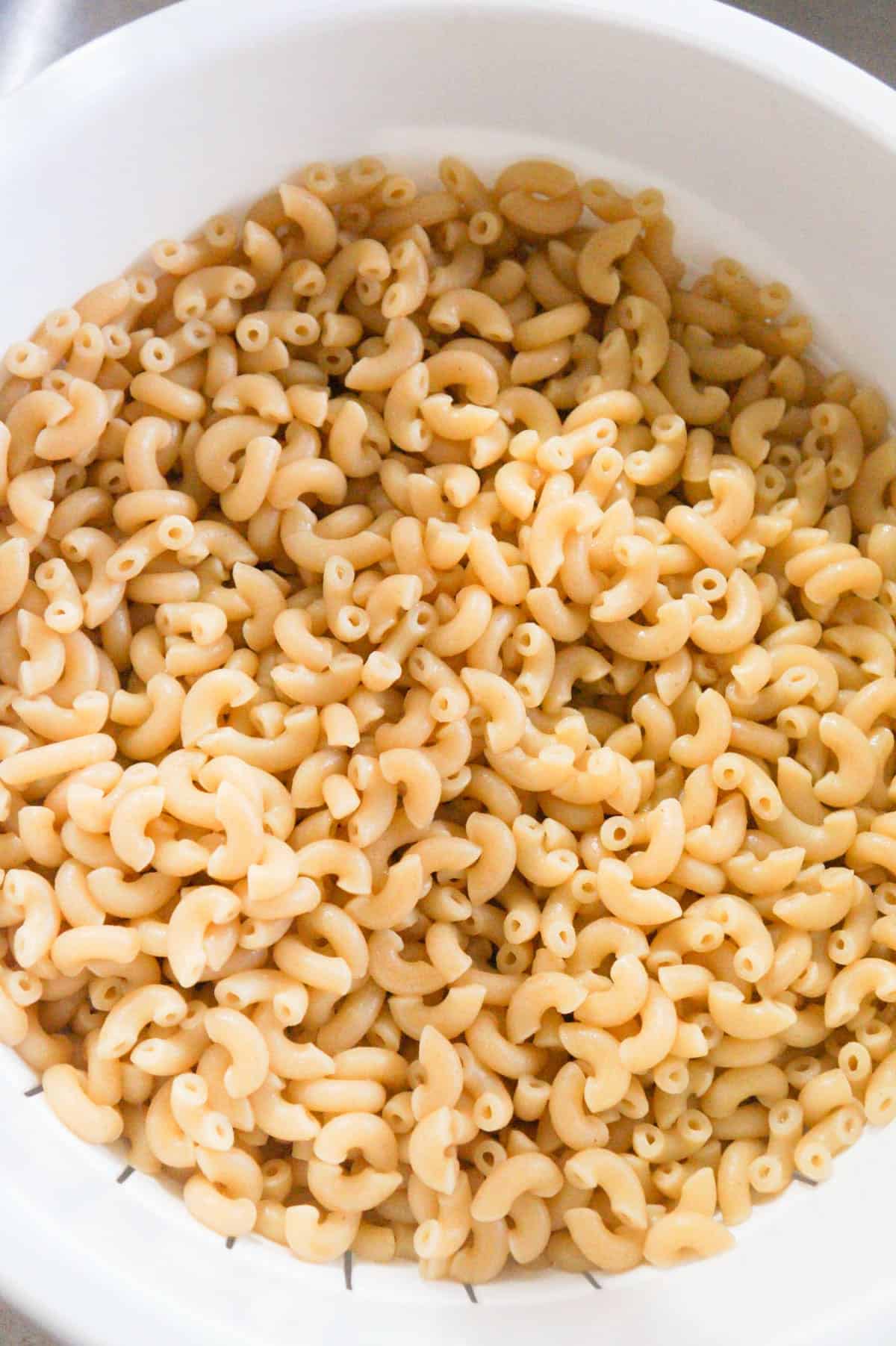 cooked macaroni noodles in a strainer 