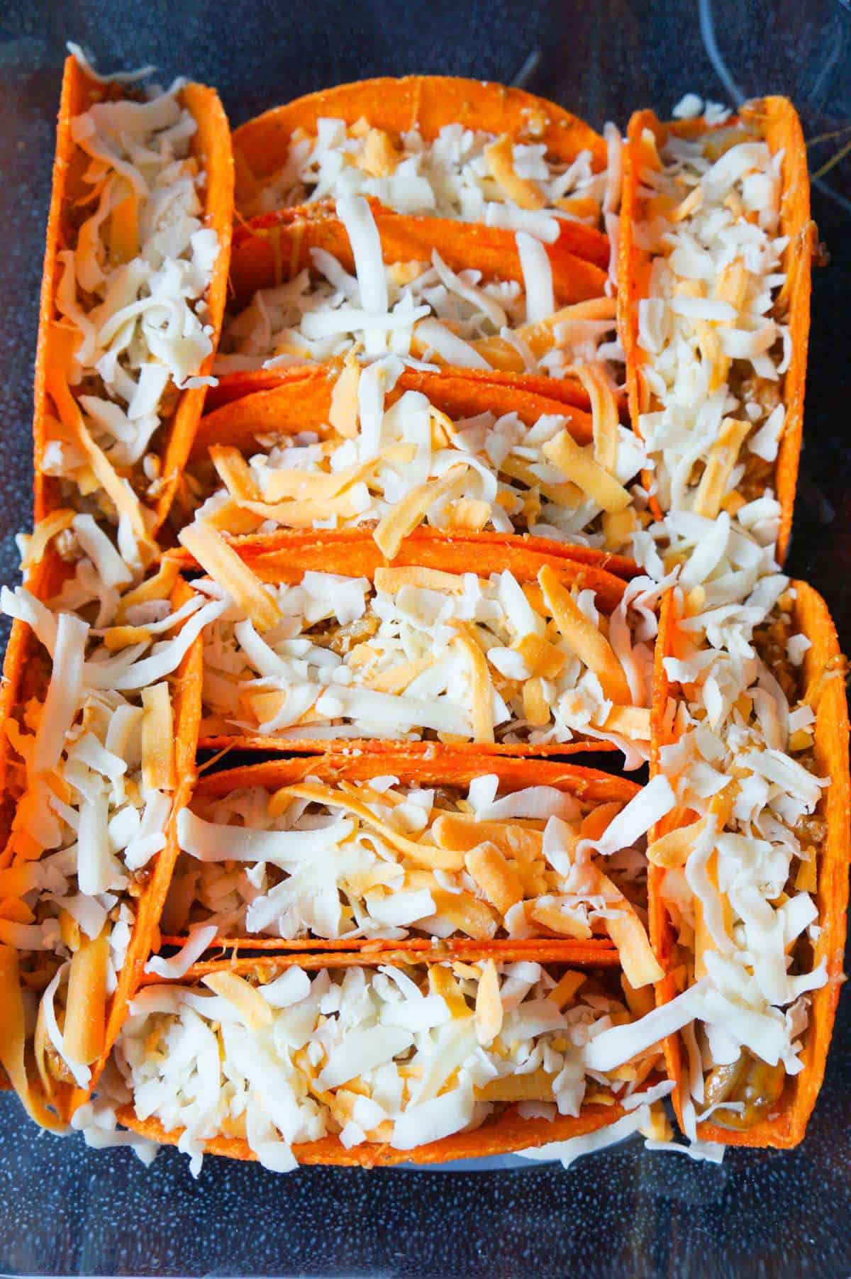 shredded cheese on top of beef tacos before baking