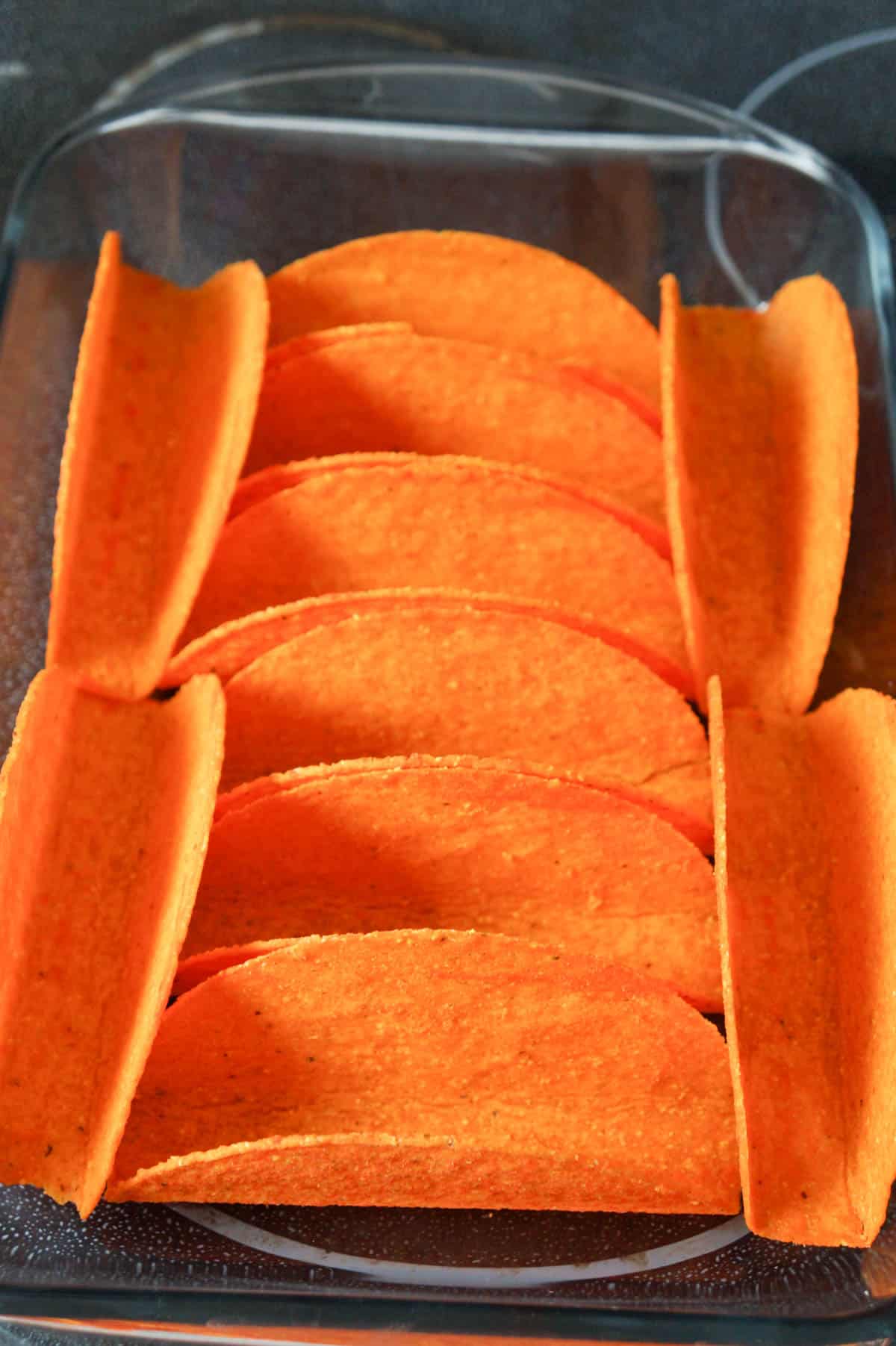 nacho cheese flavoured taco shells in a baking dish