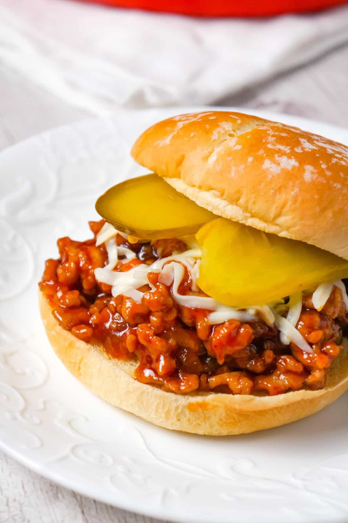 Honey BBQ Chicken Sloppy Joes are an easy weeknight dinner recipe using ground chicken, tossed in honey and BBQ sauce and topped with mozzarella cheese and dill pickles.