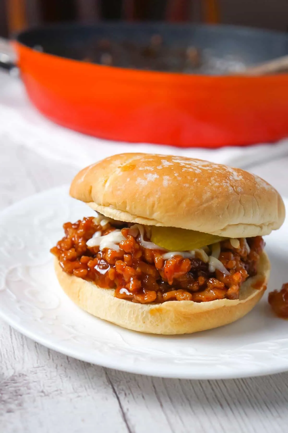 Honey BBQ Chicken Sloppy Joes are an easy weeknight dinner recipe using ground chicken, tossed in honey and BBQ sauce and topped with mozzarella cheese and dill pickles.