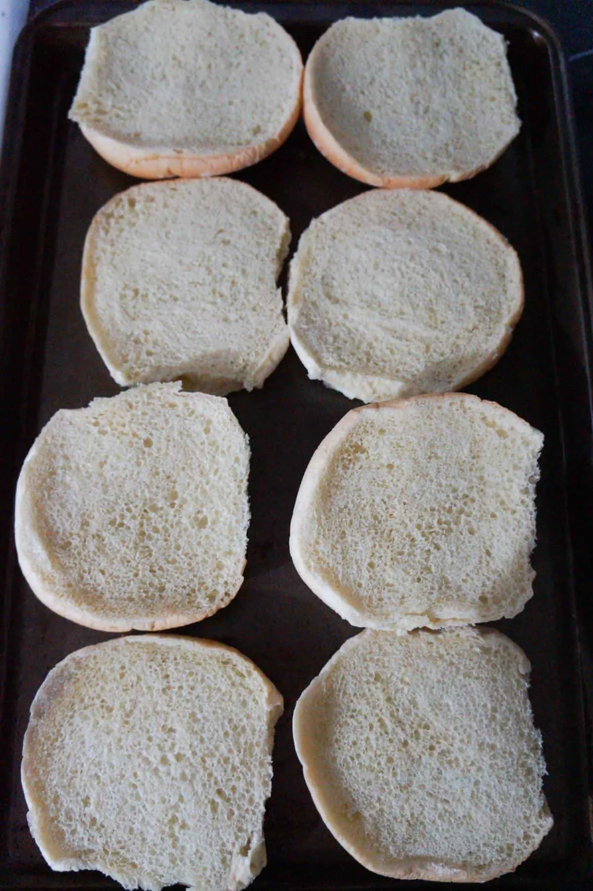 large hamburger buns on a baking sheet