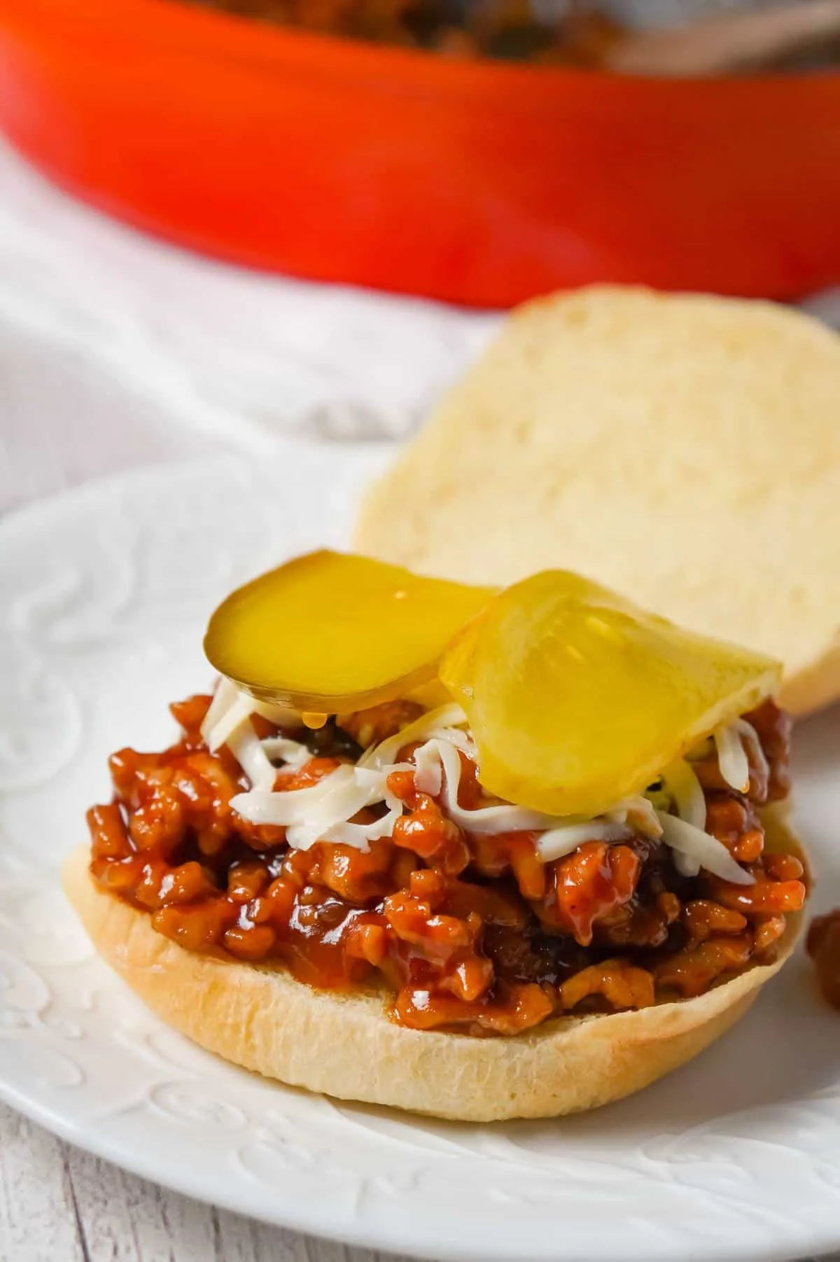 Honey BBQ Chicken Sloppy Joes are an easy weeknight dinner recipe using ground chicken, tossed in honey and BBQ sauce and topped with mozzarella cheese and dill pickles.