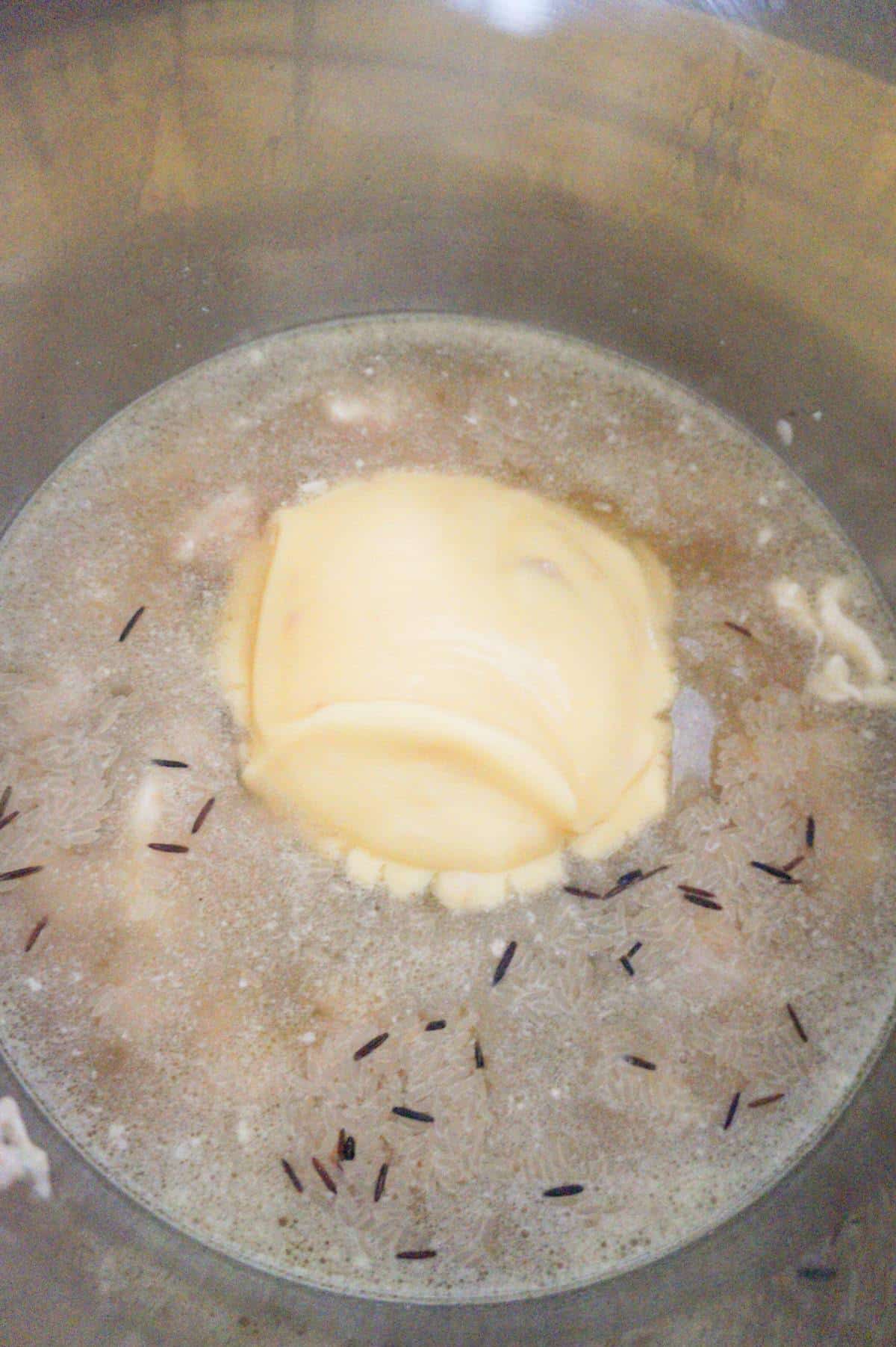 condensed cream of chicken soup on top of water and chicken chunks in an Instant Pot