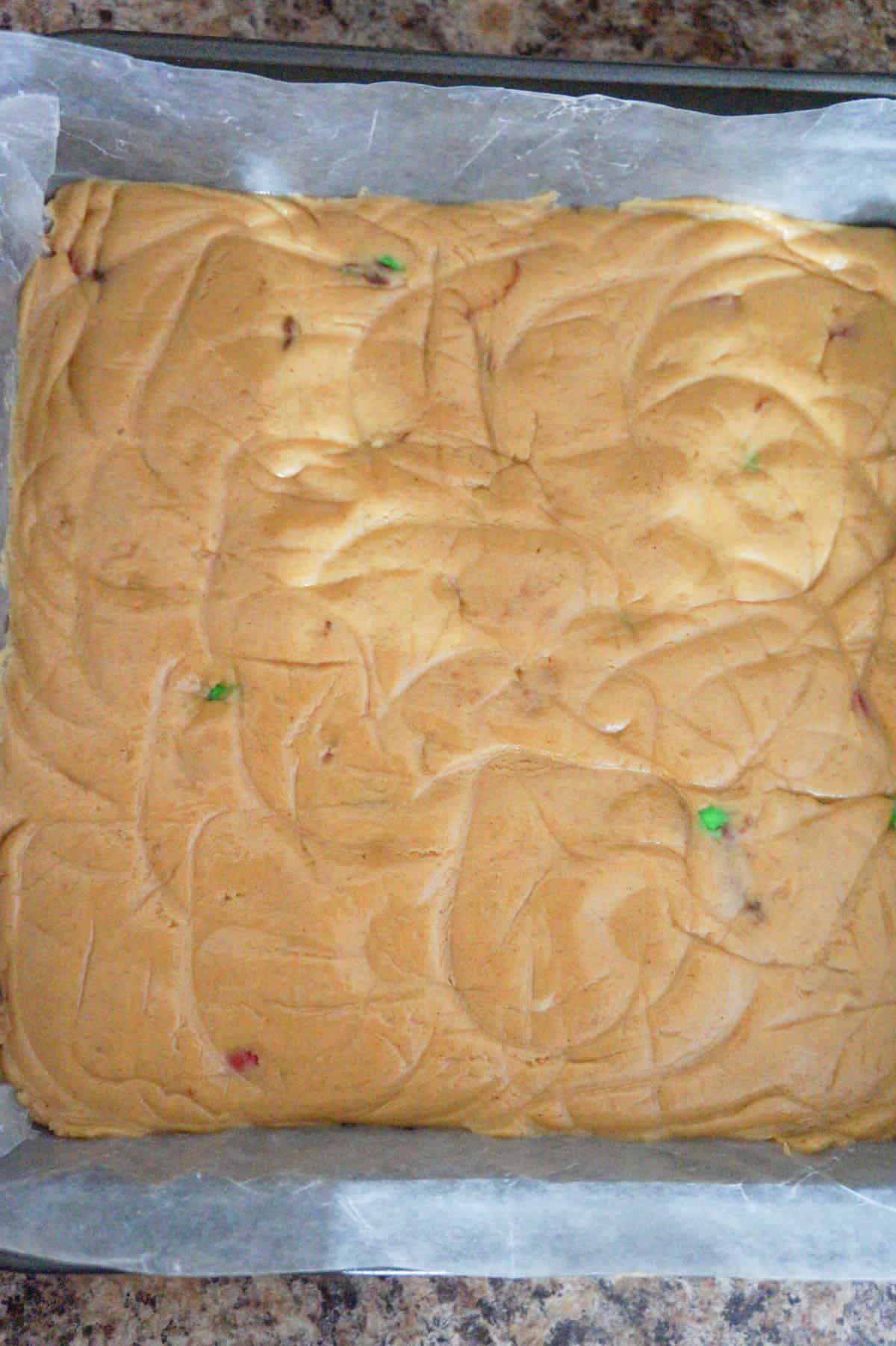 peanut butter fudge mixture in a wax paper lined baking pan