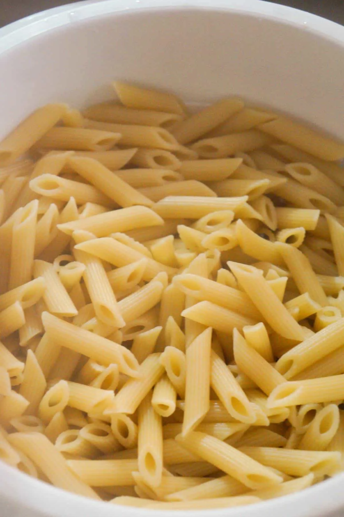 cooked penne noodles in a collander