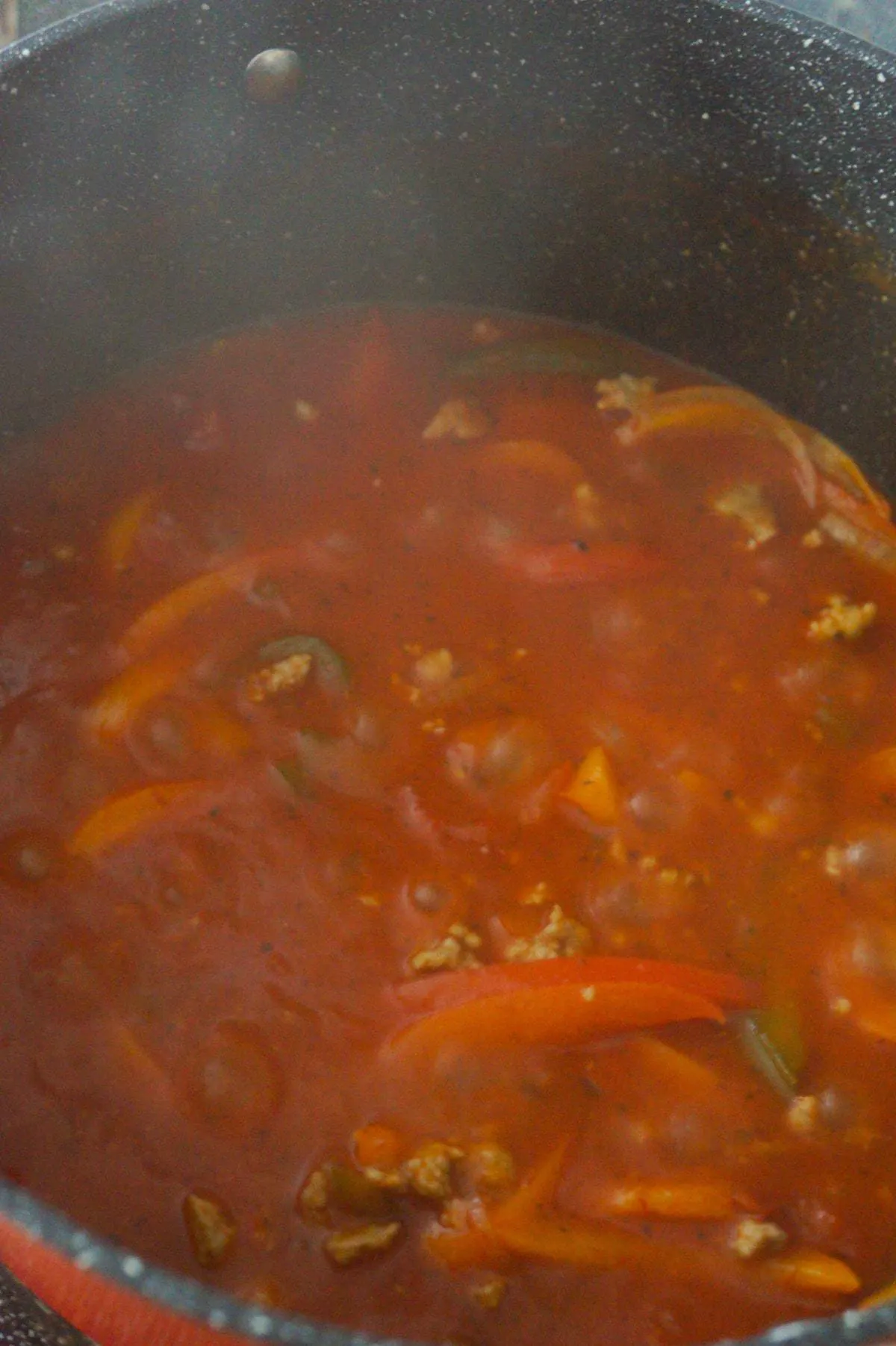 sausage and peppers marinara sauce cooking in a large pot