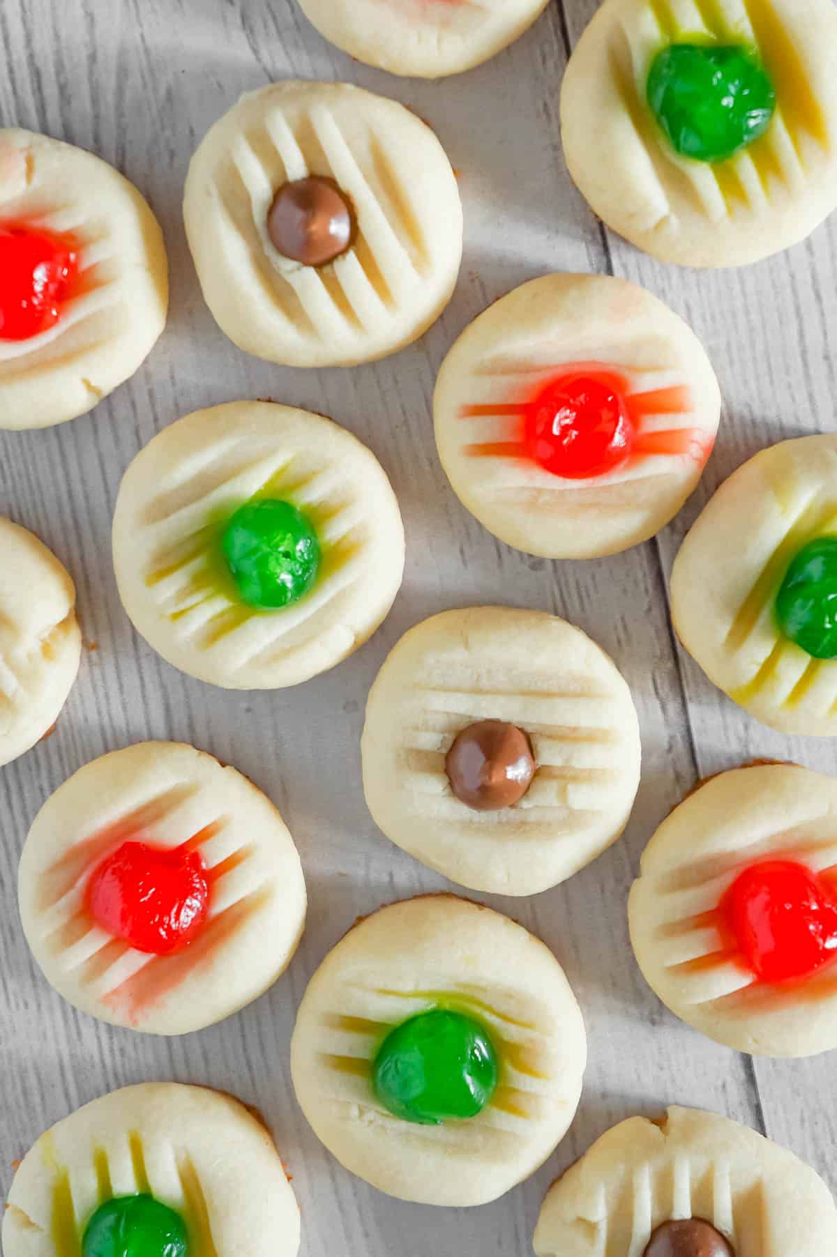 Whipped Christmas Shortbread Cookies are a buttery holiday cookie recipe that can be topped with maraschino cherries and Hershey's mini kisses.