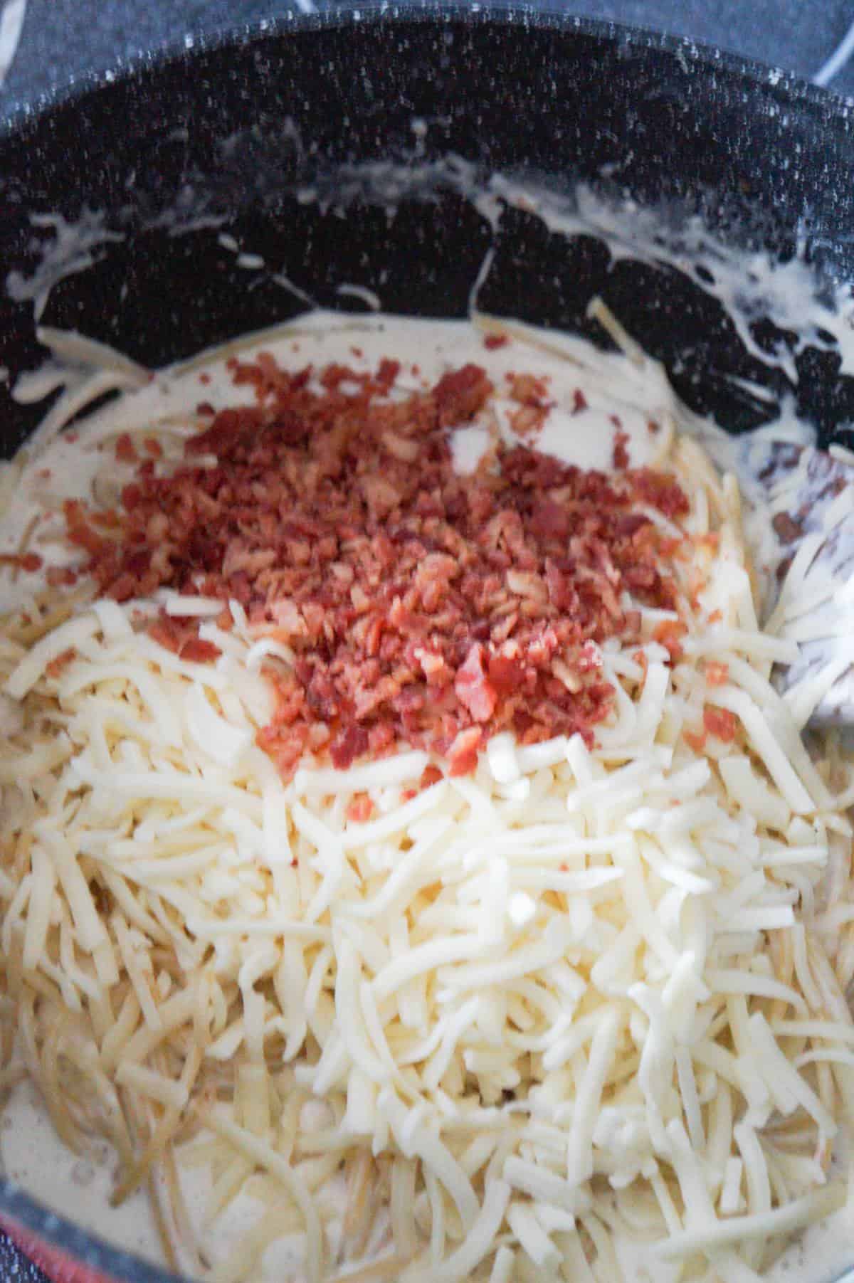 shredded mozzarella and crumbled bacon on top of creamy spaghetti in a pot