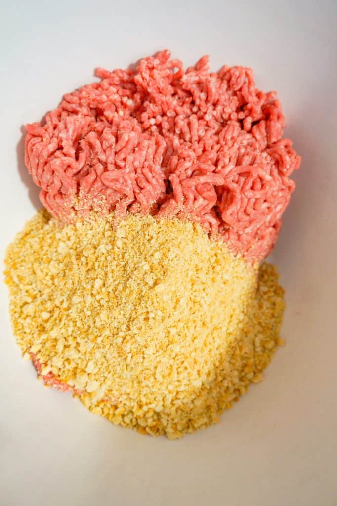 raw ground beef and Ritz cracker crumbs in a mixing bowl