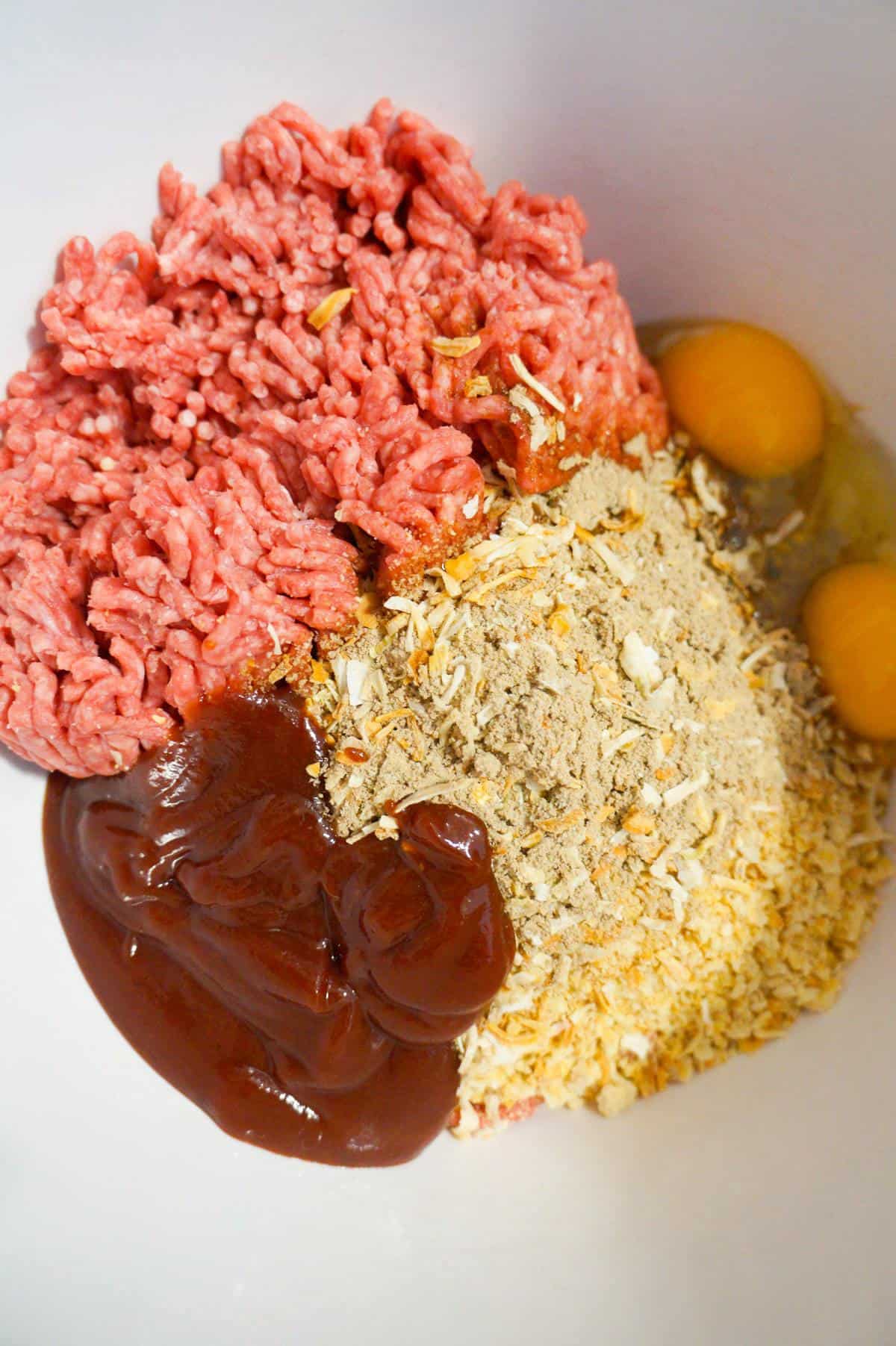 raw ground beef, Ritz cracker crumbs, bbq sauce and eggs in a mixing bowl