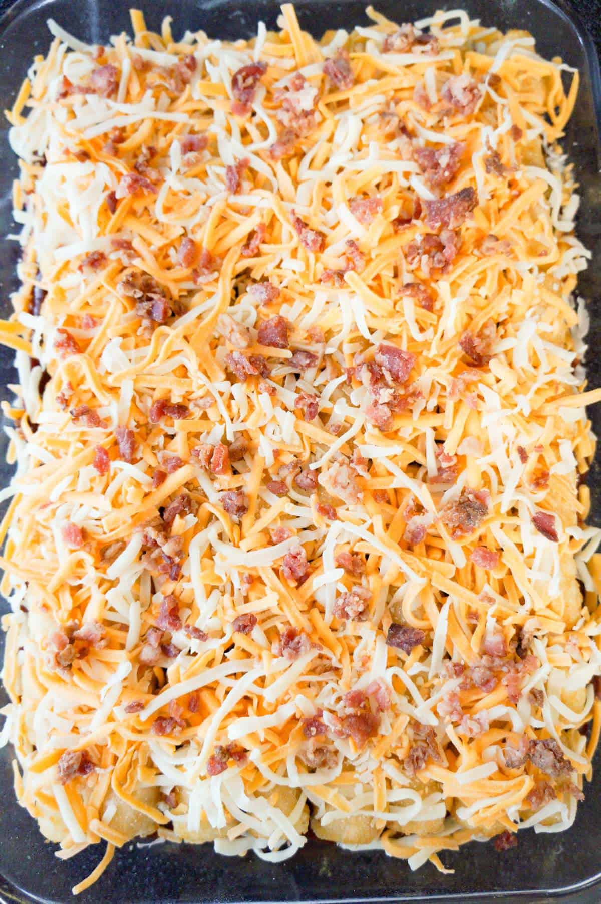 crumbled bacon and shredded cheese on top of meatloaf casserole before baking
