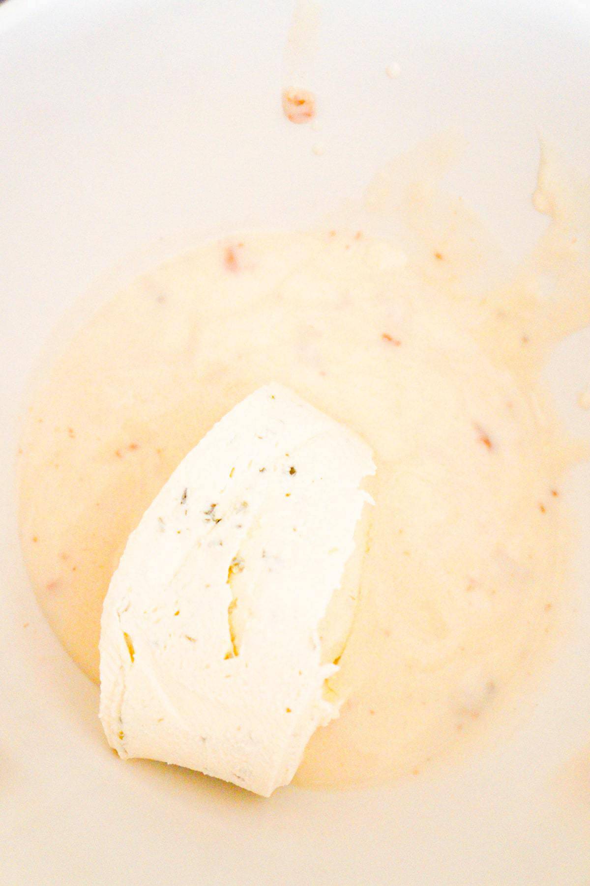 chive and onion cream cheese and condensed cream of bacon soup in a mixing bowl
