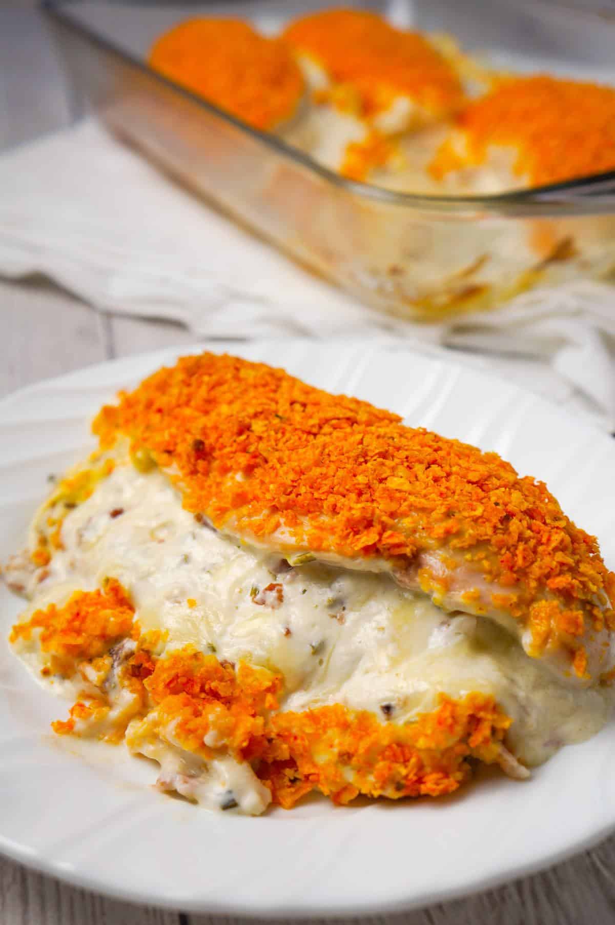 Cream Cheese and Bacon Stuffed Doritos Chicken is a delcious stuffed chicken breast recipe made with chive and onion cream cheese, cream of bacon soup, cumbled bacon and crushed Doritos.