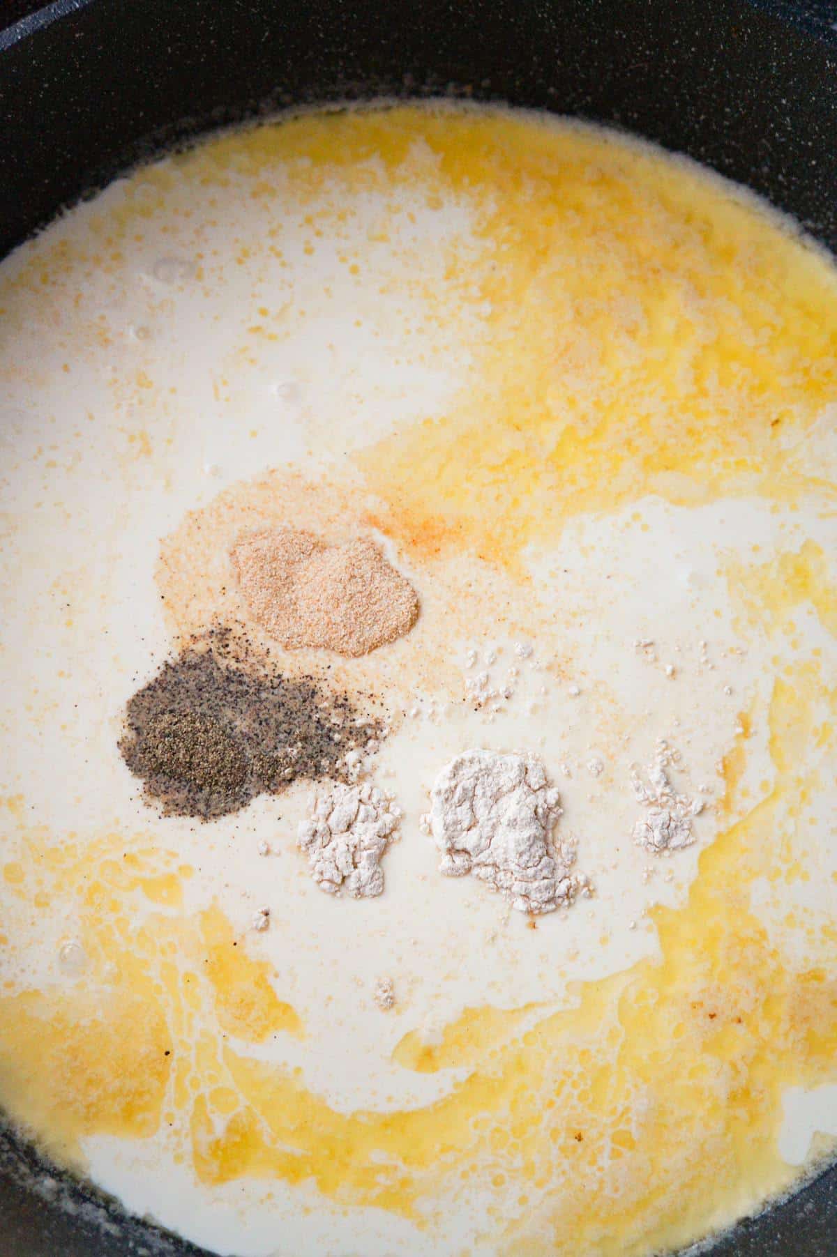 spices on top of heavy cream in a large pan