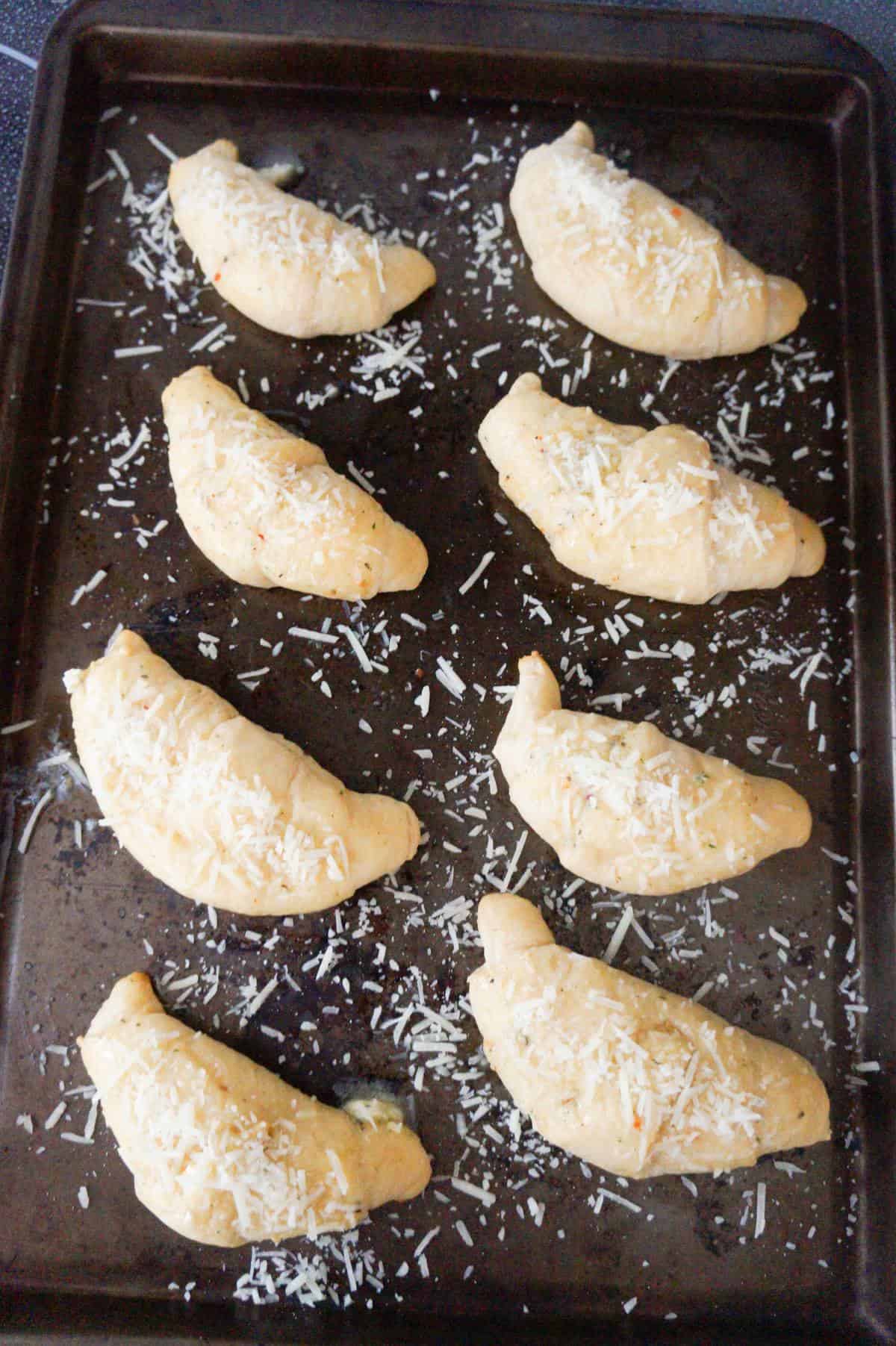 crescent rolls with shredded parmesan cheese and garlic butter on top