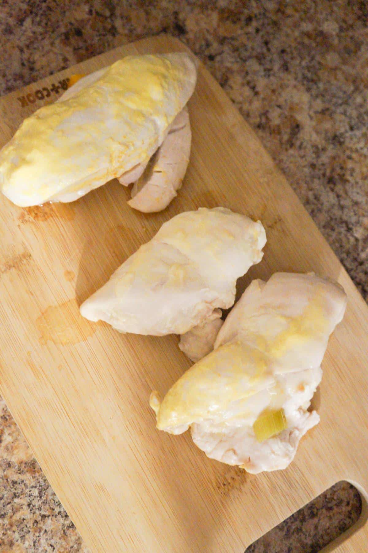 cooked chicken breasts on a cutting board