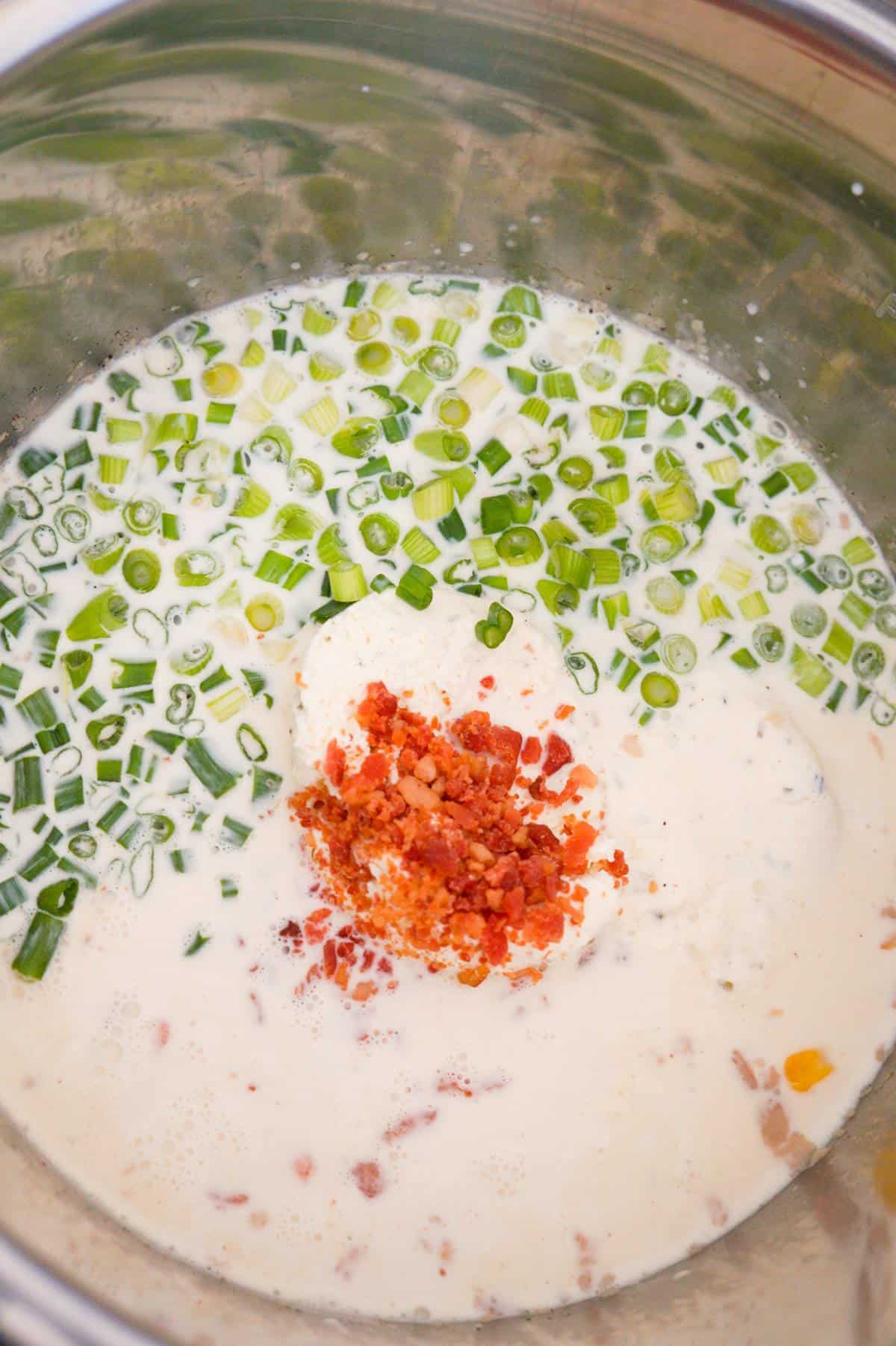 crumbled bacon and chopped green onions on top of corn chowder in the Instant Pot