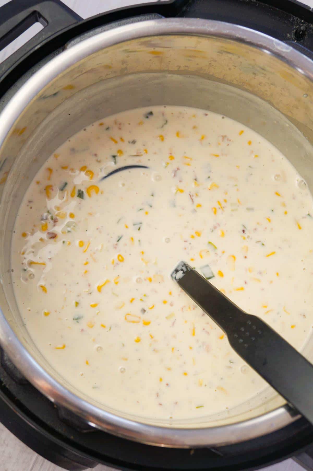Instant Pot Corn Chowder with Cream Cheese and Bacon is a hearty soup recipe loaded with corn, crumbled bacon, Philadelphia whipped chive cream cheese and chopped green onions.