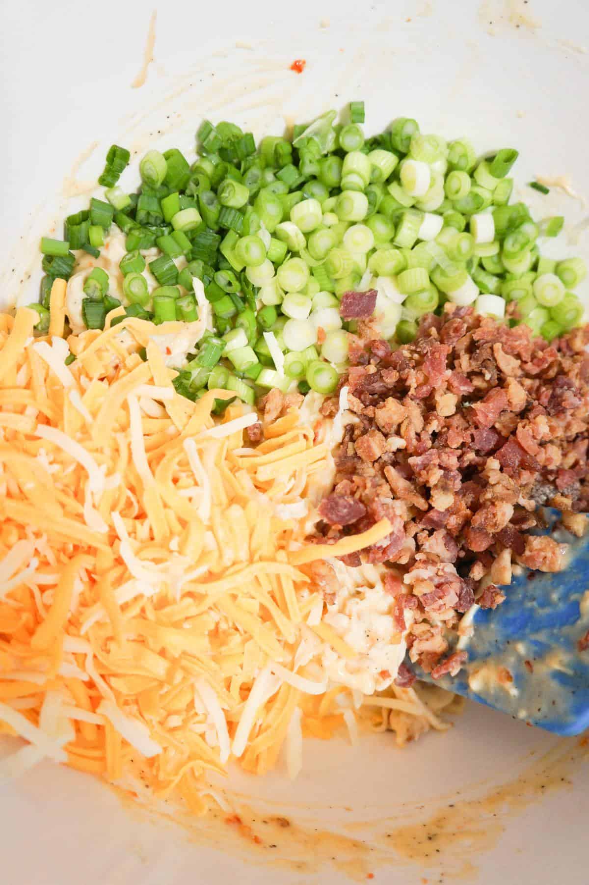 chopped green onions, crumbled bacon and shredded cheese in a mixing bowl