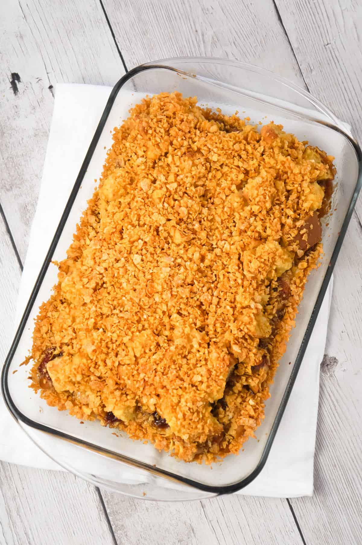 Peanut Butter and Jelly French Toast Casserole is a delicious breakfast casserole made with Italian bread loaded with peanut butter and strawberry jam and coated with Frosted Flakes.