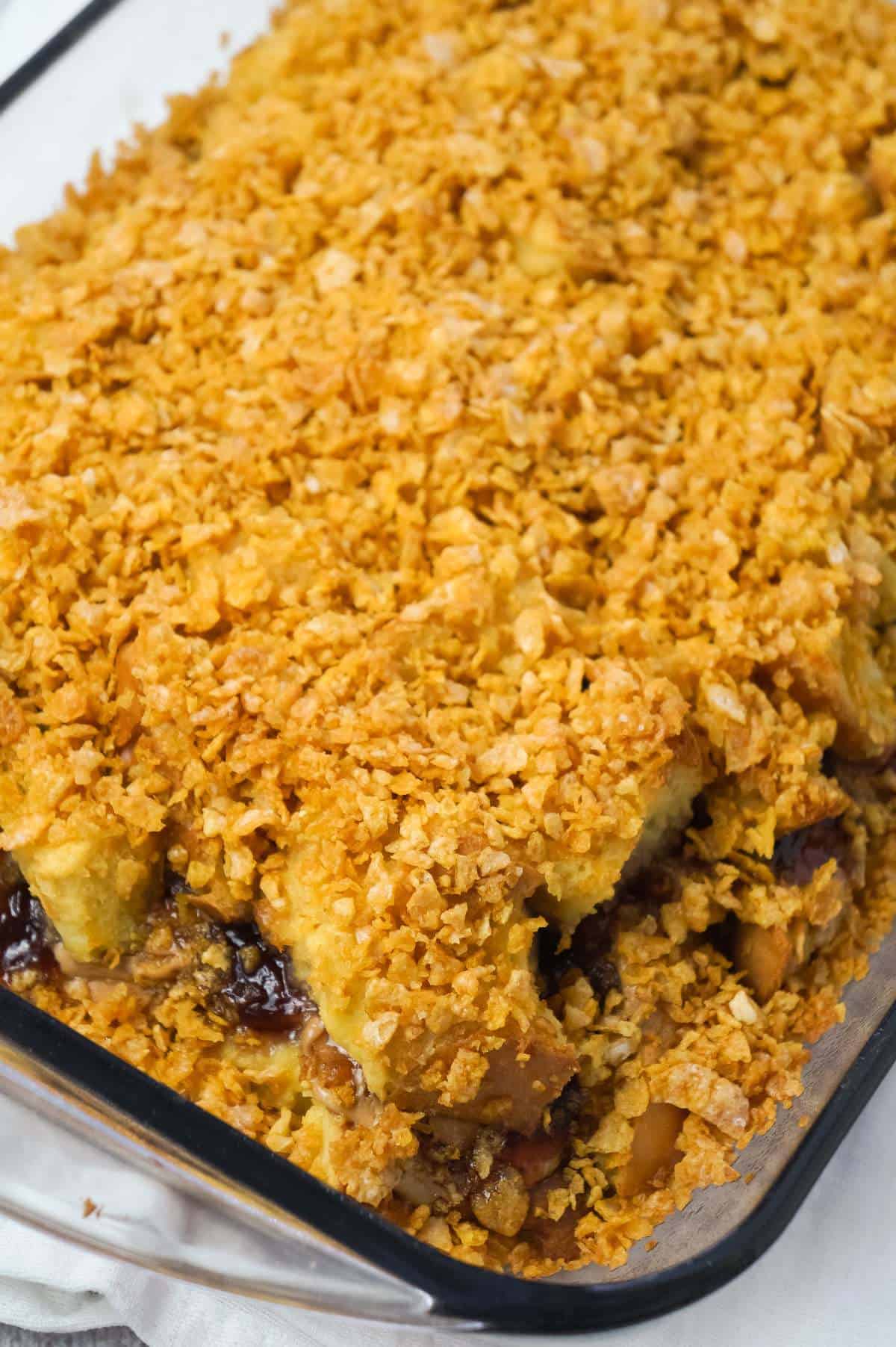 Peanut Butter and Jelly French Toast Casserole is a delicious breakfast casserole made with Italian bread loaded with peanut butter and strawberry jam and coated with Frosted Flakes.