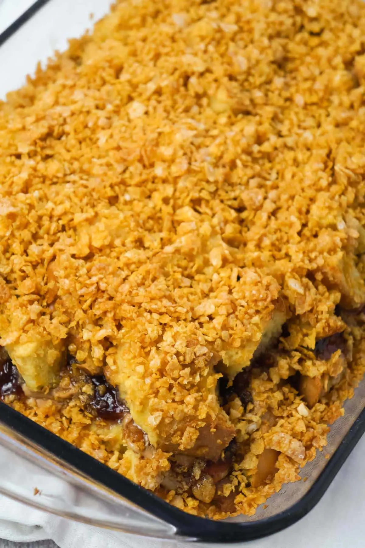 Peanut Butter and Jelly French Toast Casserole is a delicious breakfast casserole made with Italian bread loaded with peanut butter and strawberry jam and coated with Frosted Flakes.