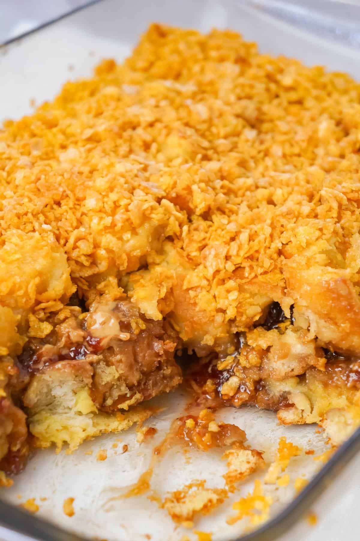 Peanut Butter and Jelly French Toast Casserole is a delicious breakfast casserole made with Italian bread loaded with peanut butter and strawberry jam and coated with Frosted Flakes.