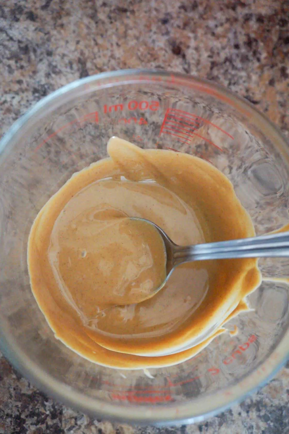 melted peanut butter in a glass measuring cup