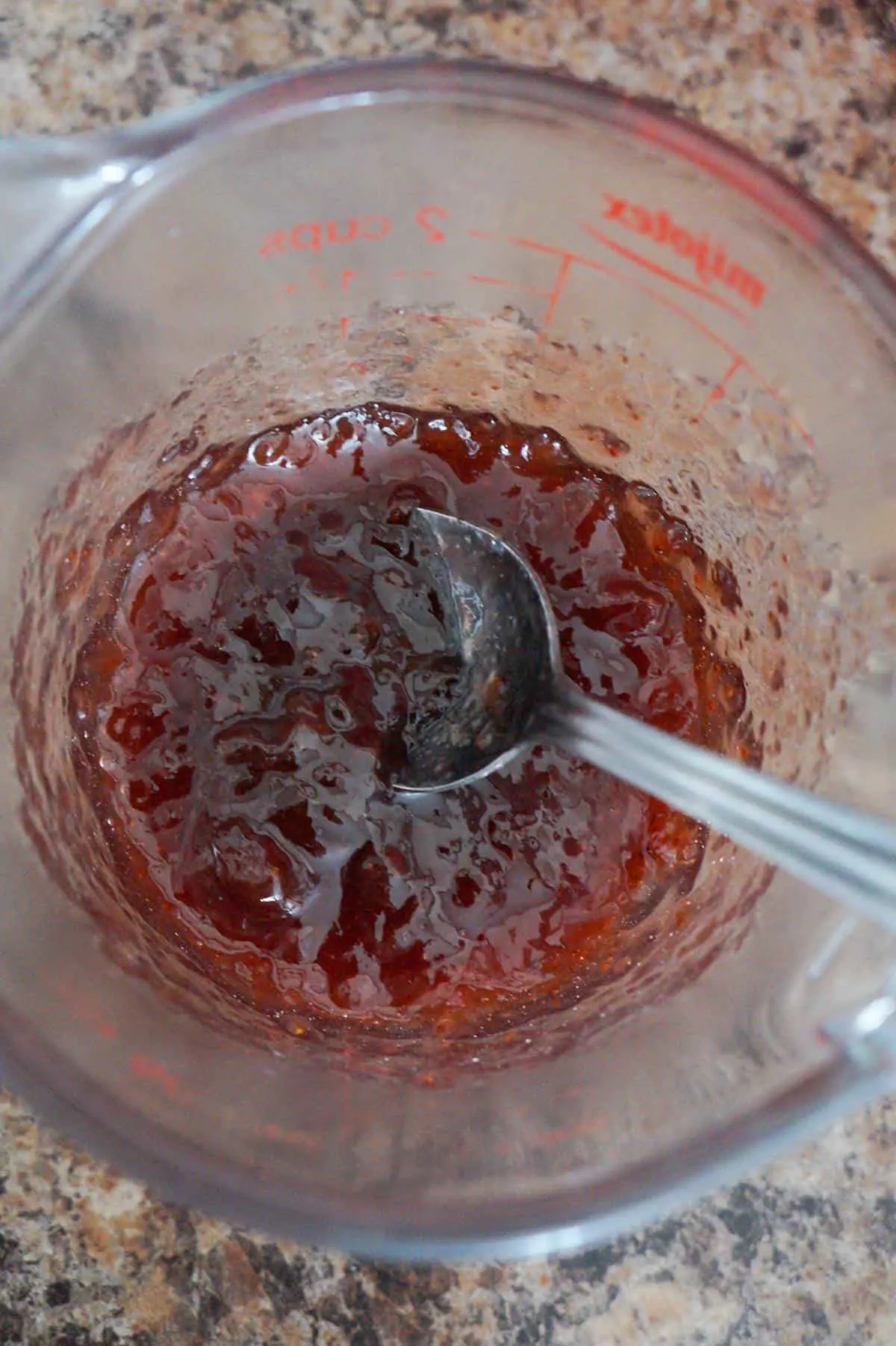 strawberry jam in a glass measuring cup