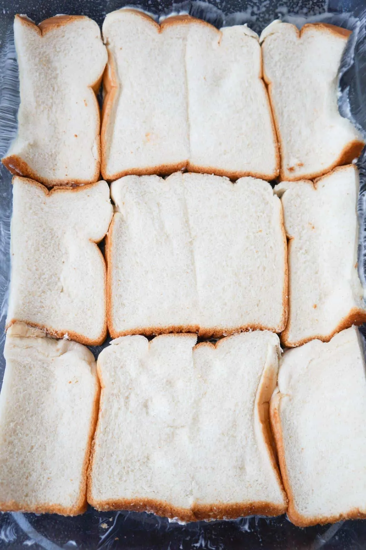 bread slices in the bottom of a 9 x 13 inch baking dish