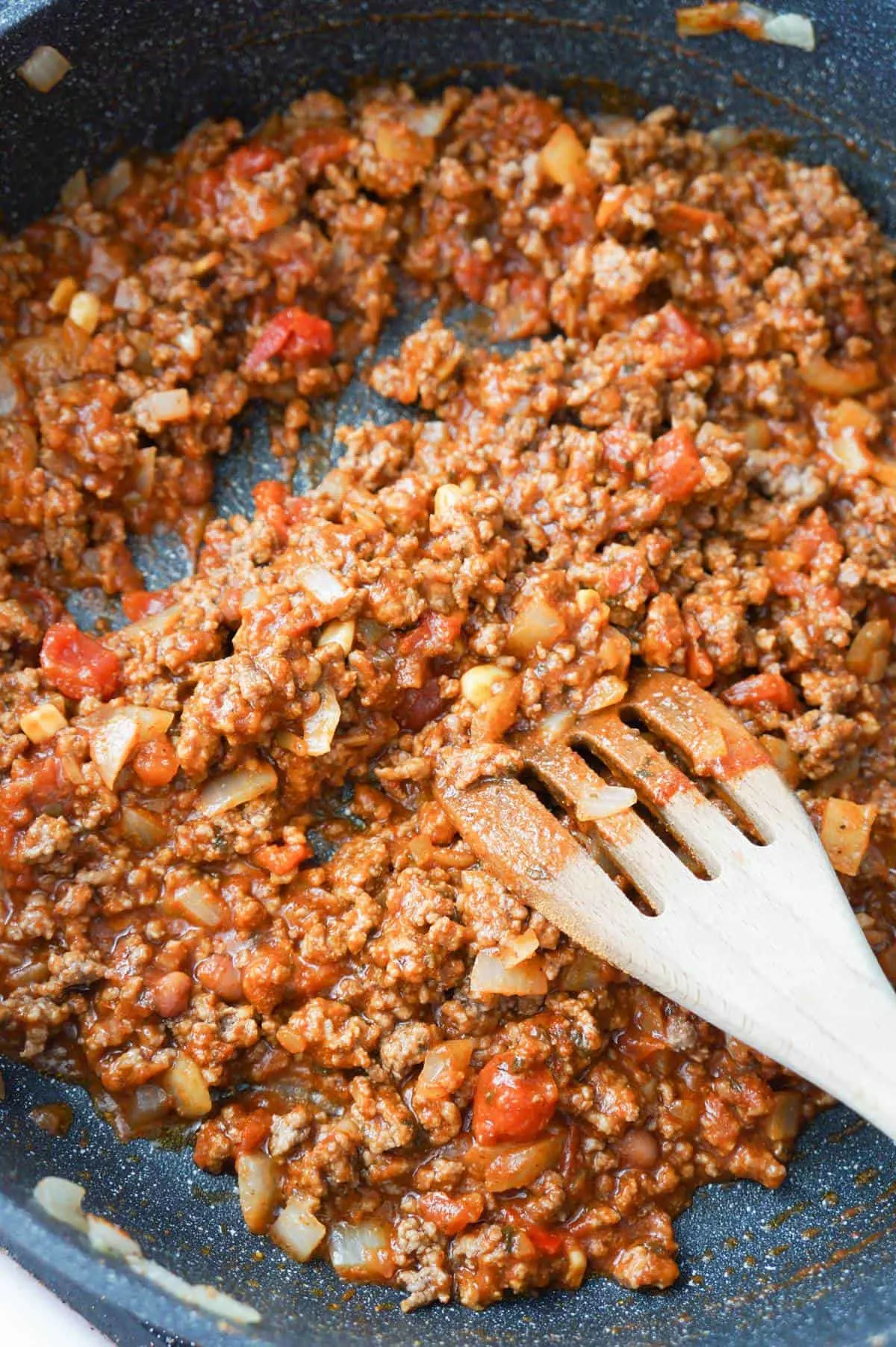 ground beef tossed in salsa and chili sauce in a saute pan