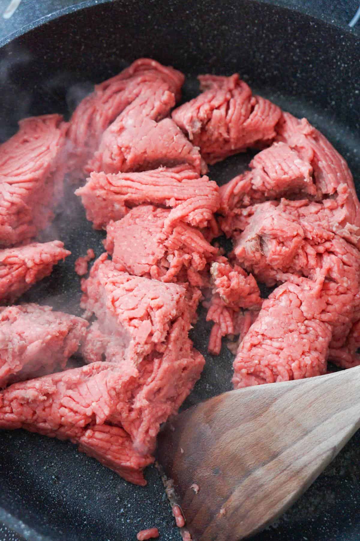raw ground beef in a saute pan