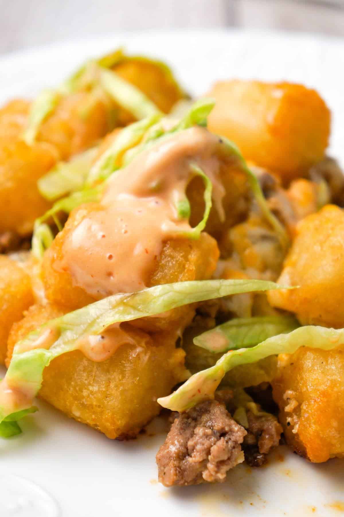 Big Mac Tater Tot Casserole is an easy dinner recipe that starts out with a base of ground beef, onions and dill pickles, all tossed in a copycat Big Mac sauce, and then topped with cheddar cheese and tater tots.