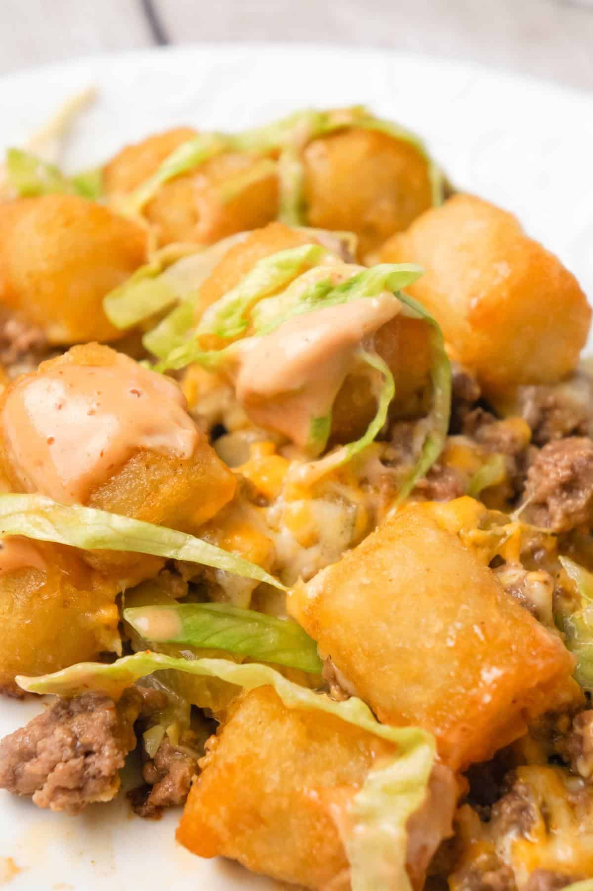 Big Mac Tater Tot Casserole is an easy dinner recipe that starts out with a base of ground beef, onions and dill pickles, all tossed in a copycat Big Mac sauce, and then topped with cheddar cheese and tater tots.