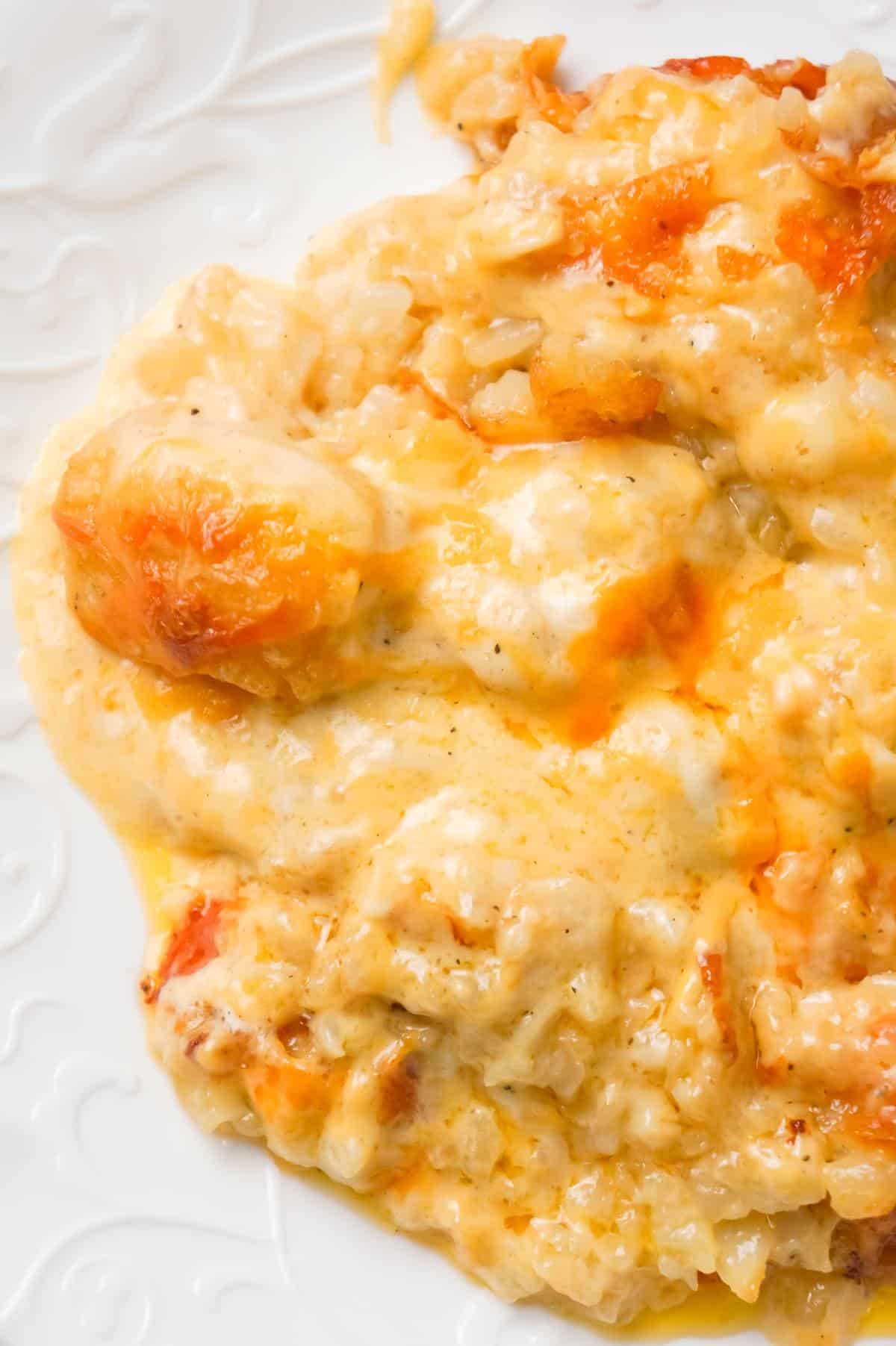 Cheesy Garlic Tater Tot Casserole is an easy potato side dish recipe using heavy cream, cheddar cheese soup, frozen tater tots, garlic puree and shredded mozzarella, cheddar and Parmesan cheese.