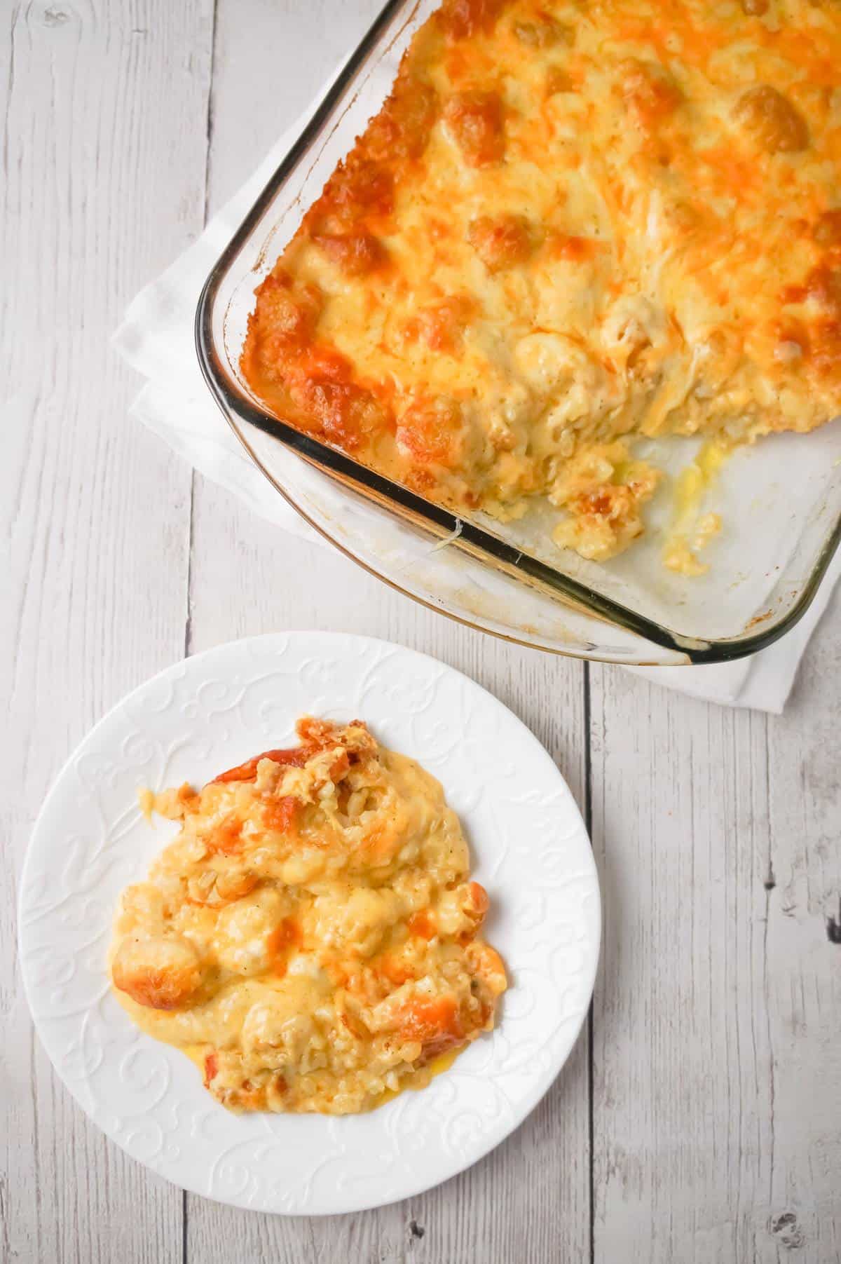 Cheesy Garlic Tater Tot Casserole is an easy potato side dish recipe using heavy cream, cheddar cheese soup, frozen tater tots, garlic puree and shredded mozzarella, cheddar and Parmesan cheese.