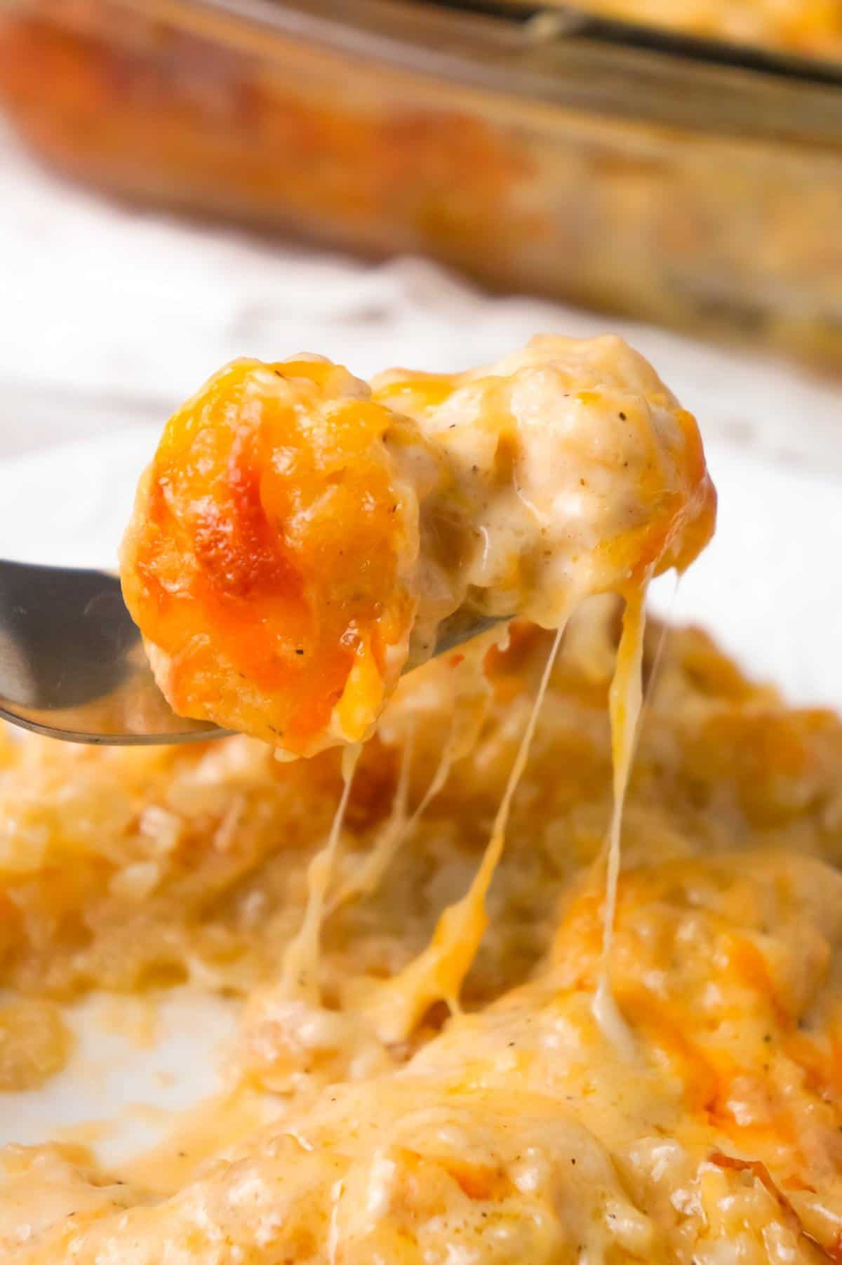 Cheesy Garlic Tater Tot Casserole is an easy potato side dish recipe using heavy cream, cheddar cheese soup, frozen tater tots, garlic puree and shredded mozzarella, cheddar and Parmesan cheese.