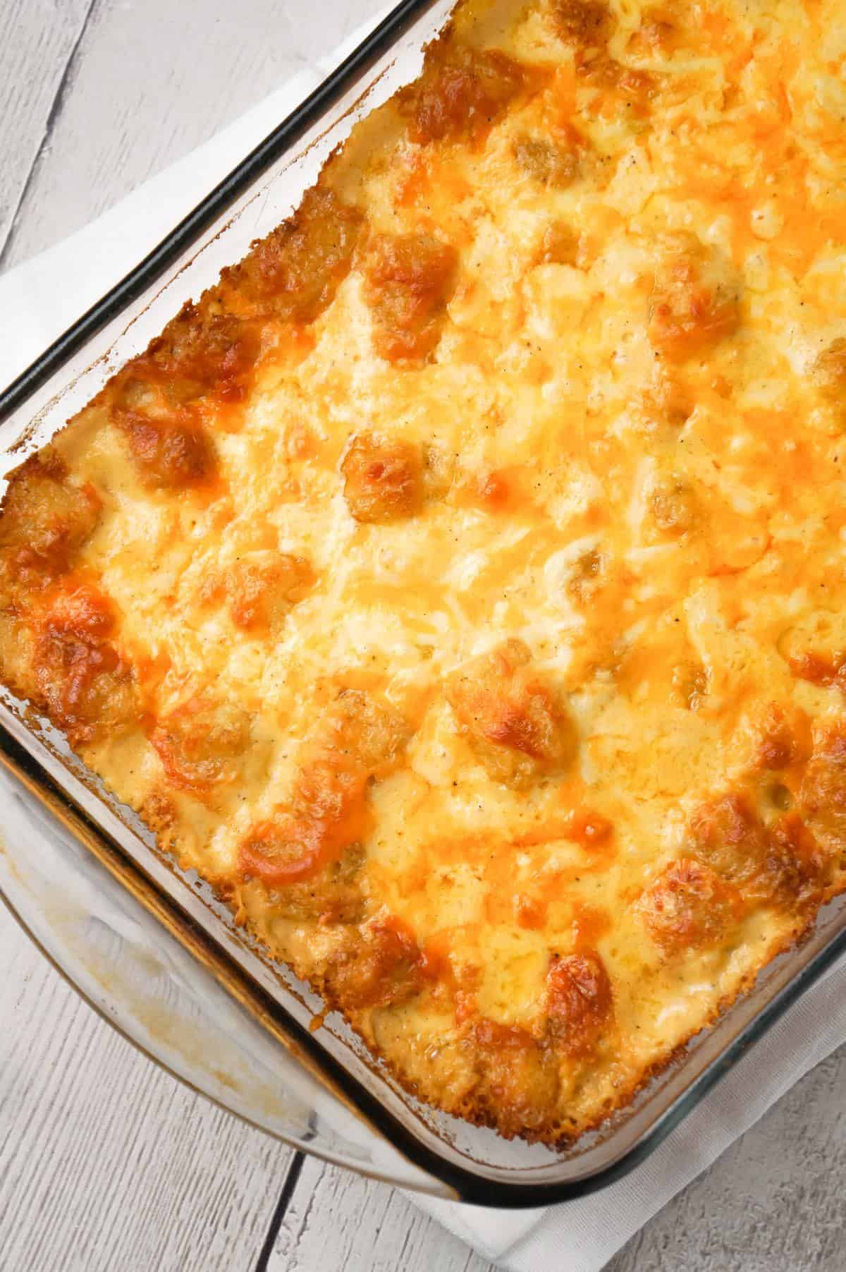 Cheesy Garlic Tater Tot Casserole is an easy potato side dish recipe using heavy cream, cheddar cheese soup, frozen tater tots, garlic puree and shredded mozzarella, cheddar and Parmesan cheese.