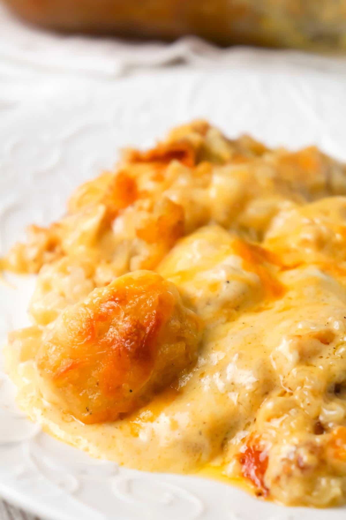 Cheesy Garlic Tater Tot Casserole is an easy potato side dish recipe using heavy cream, cheddar cheese soup, frozen tater tots, garlic puree and shredded mozzarella, cheddar and Parmesan cheese.