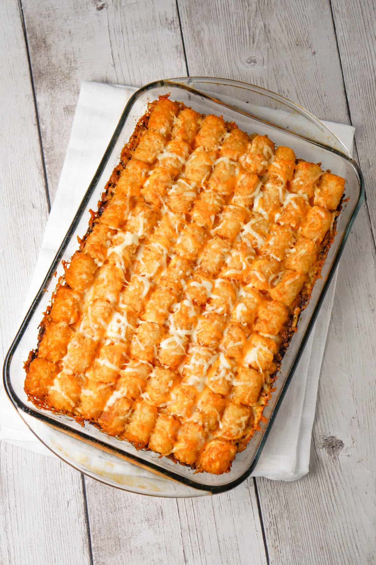Dr Pepper Pork Tater Tot Casserole is a hearty dish with a base of ground pork cooked in Dr Pepper and BBQ sauce and topped with tater tots and shredded cheese.