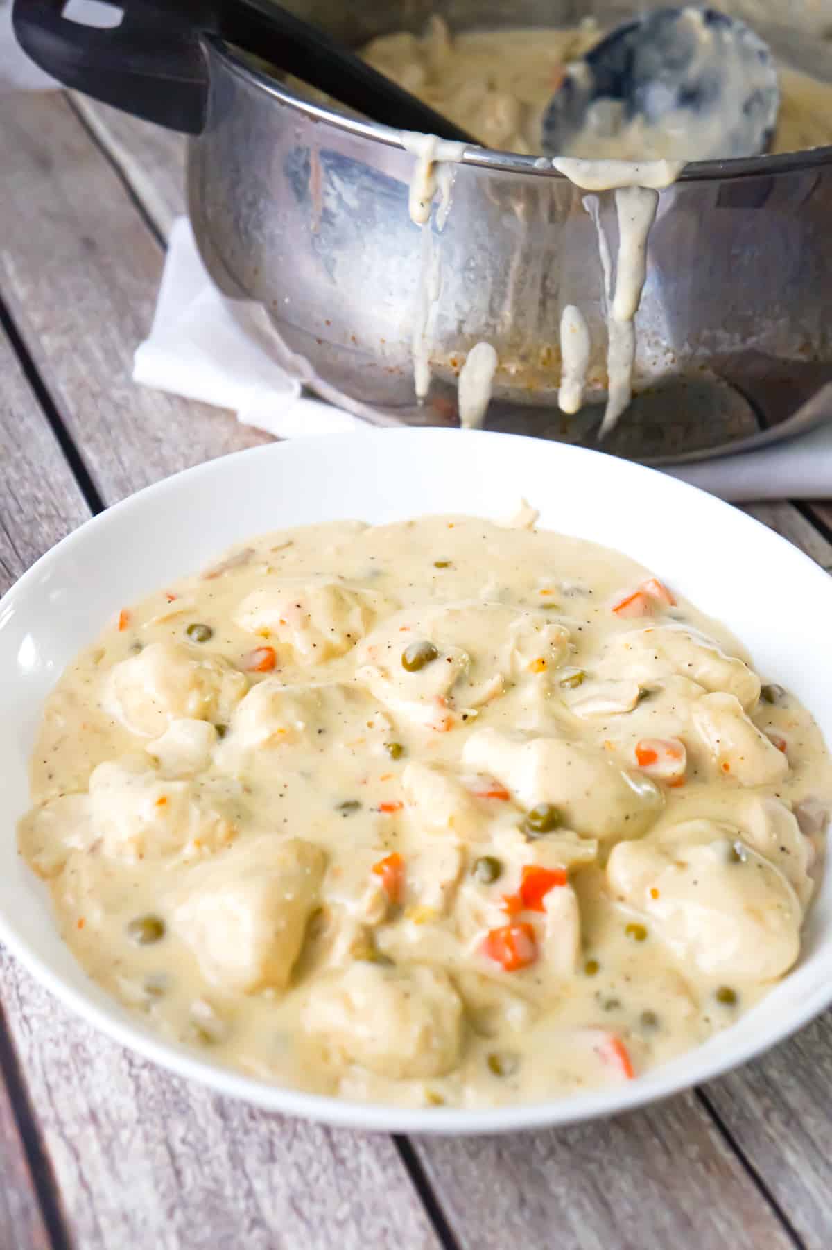 Easy Chicken and Dumplings with Biscuits is a hearty dinner recipe loaded with shredded chicken, Pillsbury biscuit pieces, peas and carrots all in a thick and creamy sauce.