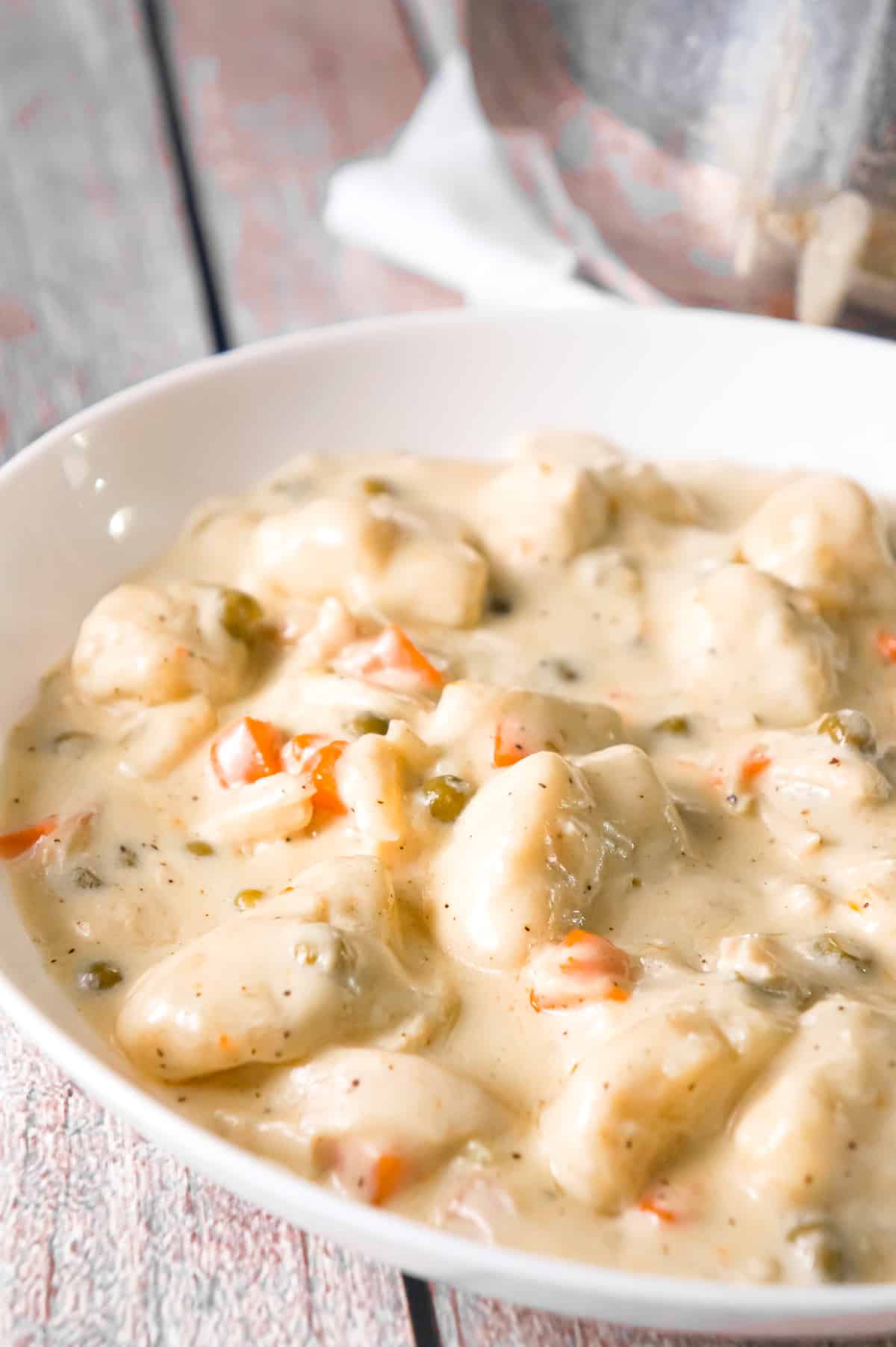 Easy Chicken and Dumplings with Biscuits is a hearty dinner recipe loaded with shredded chicken, Pillsbury biscuit pieces, peas and carrots all in a thick and creamy sauce.