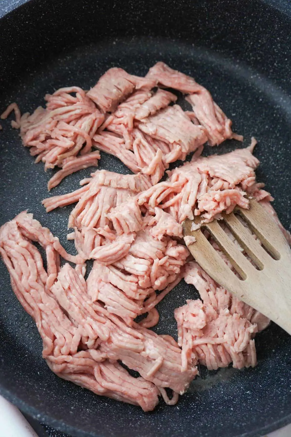 raw ground chicken in a saute pan