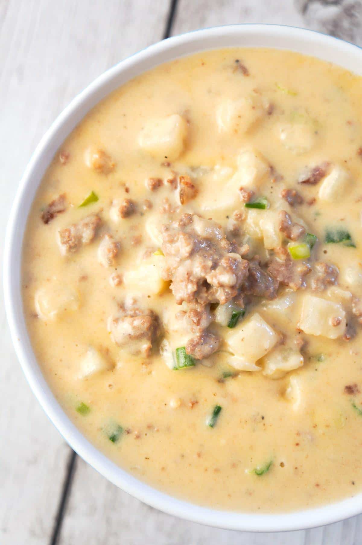 Instant Pot Bacon Cheeseburger Soup with Potatoes is a hearty pressure cooker soup recipe loaded with ground beef, crumbled bacon, diced hash brown potatoes, chopped green onions and cheddar cheese.