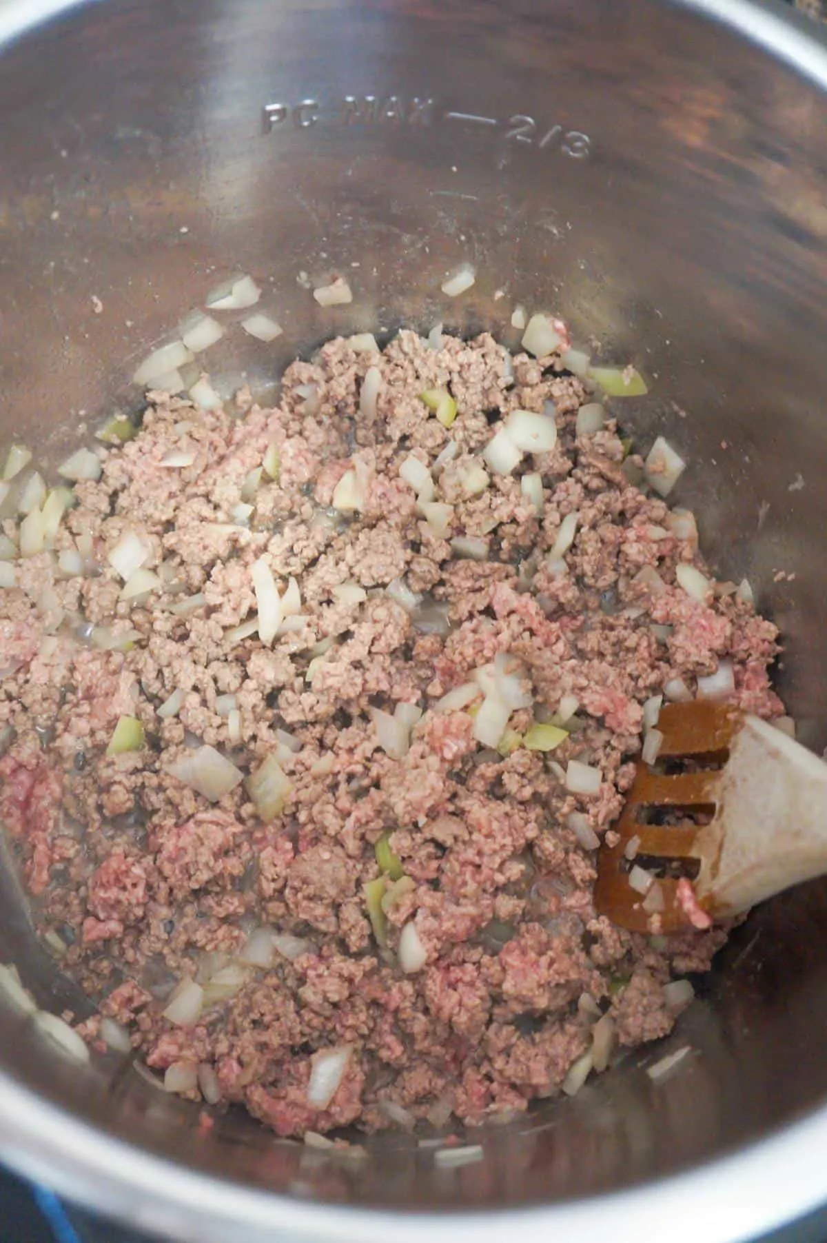 ground beef and diced onions cooking in an Instant Pot