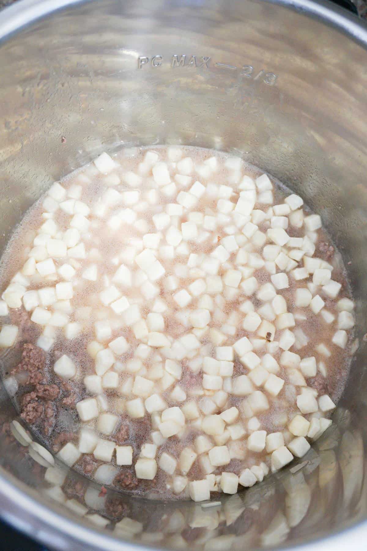 water, ground beef and diced potatoes in an Instant Pot