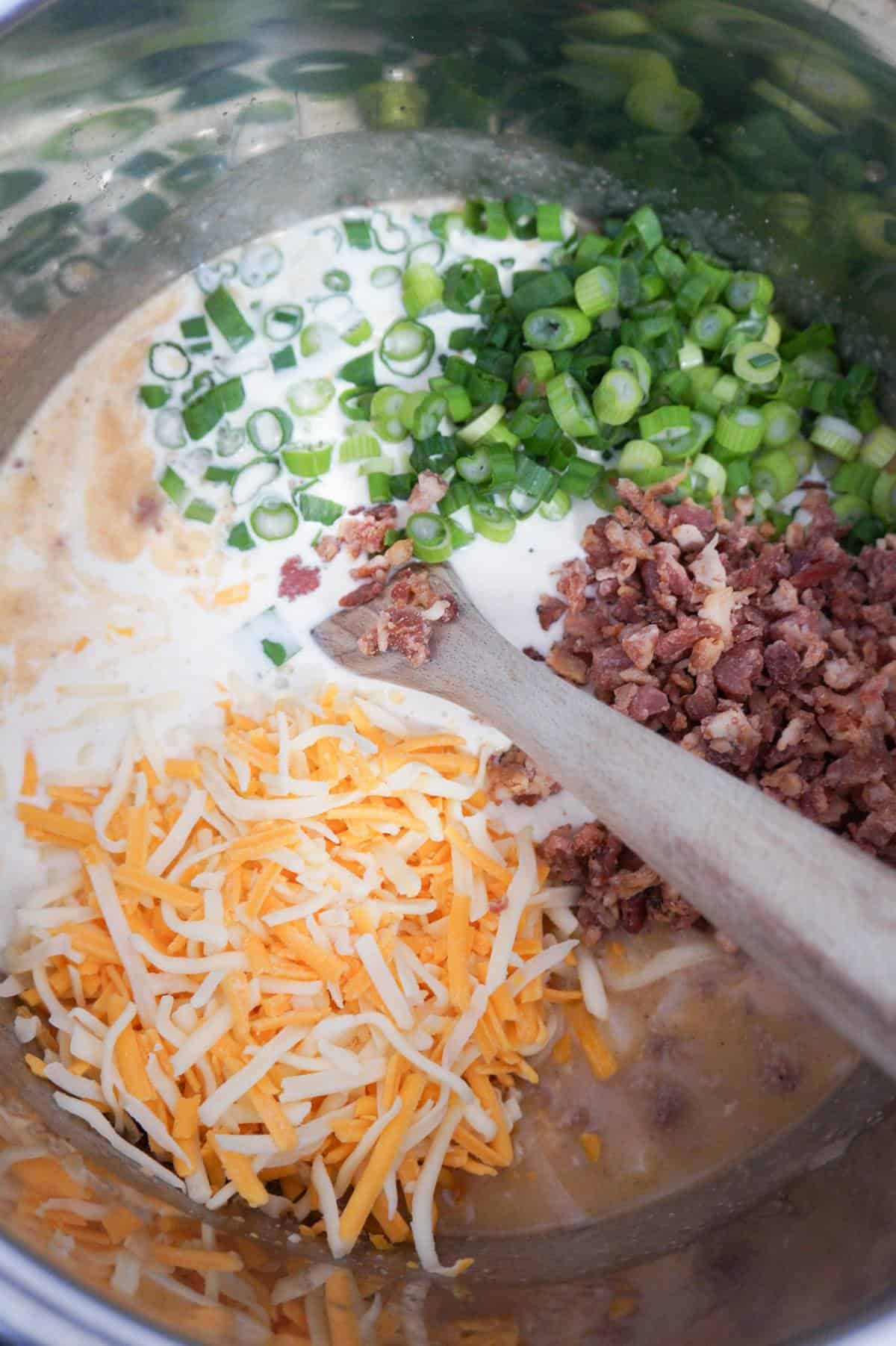 shredded cheddar cheese, chopped green onions and crumbled bacon on top of creamy soup mixture in an Instant Pot